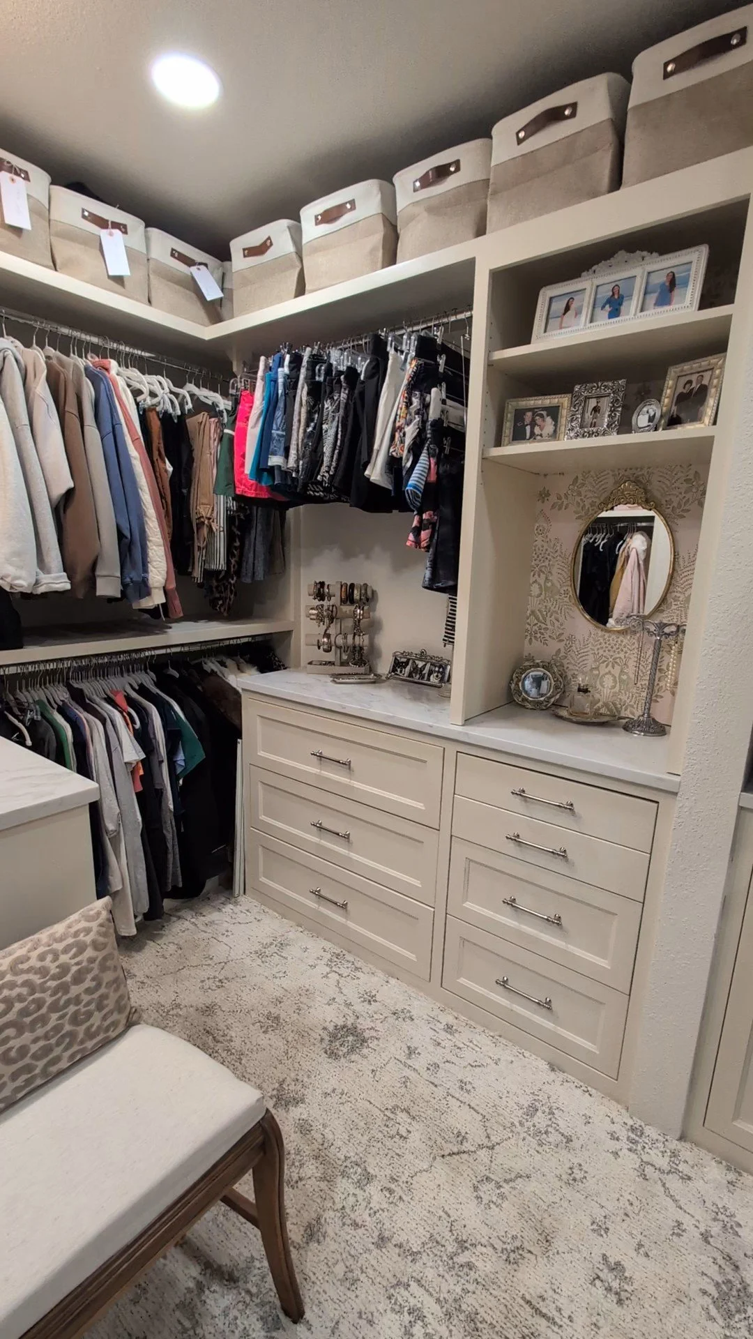 Custom closet with inset drawers, quartz countertops, wallpaper, elegant carpet
