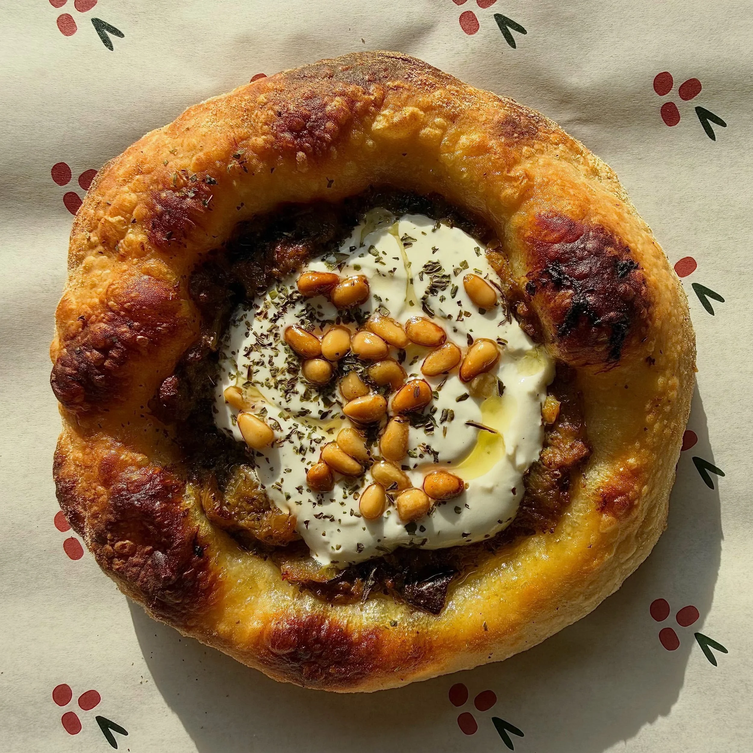 Kousa B&rsquo;Laban Safeha ! (We need zucchini emoji) 

Inspired by the traditional stuffed Zucchini (Kousa) dish, this safeha has been a staff favorite ever since we made it last year. 
Zucchini and beef filling, topped with herby yogurt, pine nuts,
