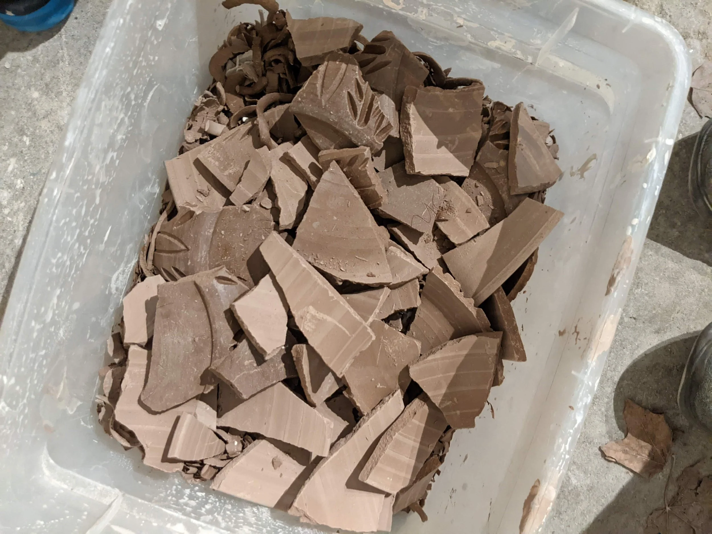 image of leather hard and bone dry broken pottery pieces in a plastic bucket