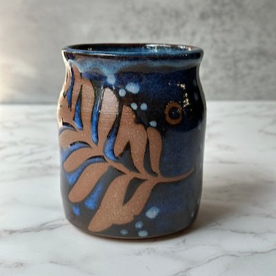 wheel-thrown pottery vase with leaf design using vinyl resist method by meesh pottery