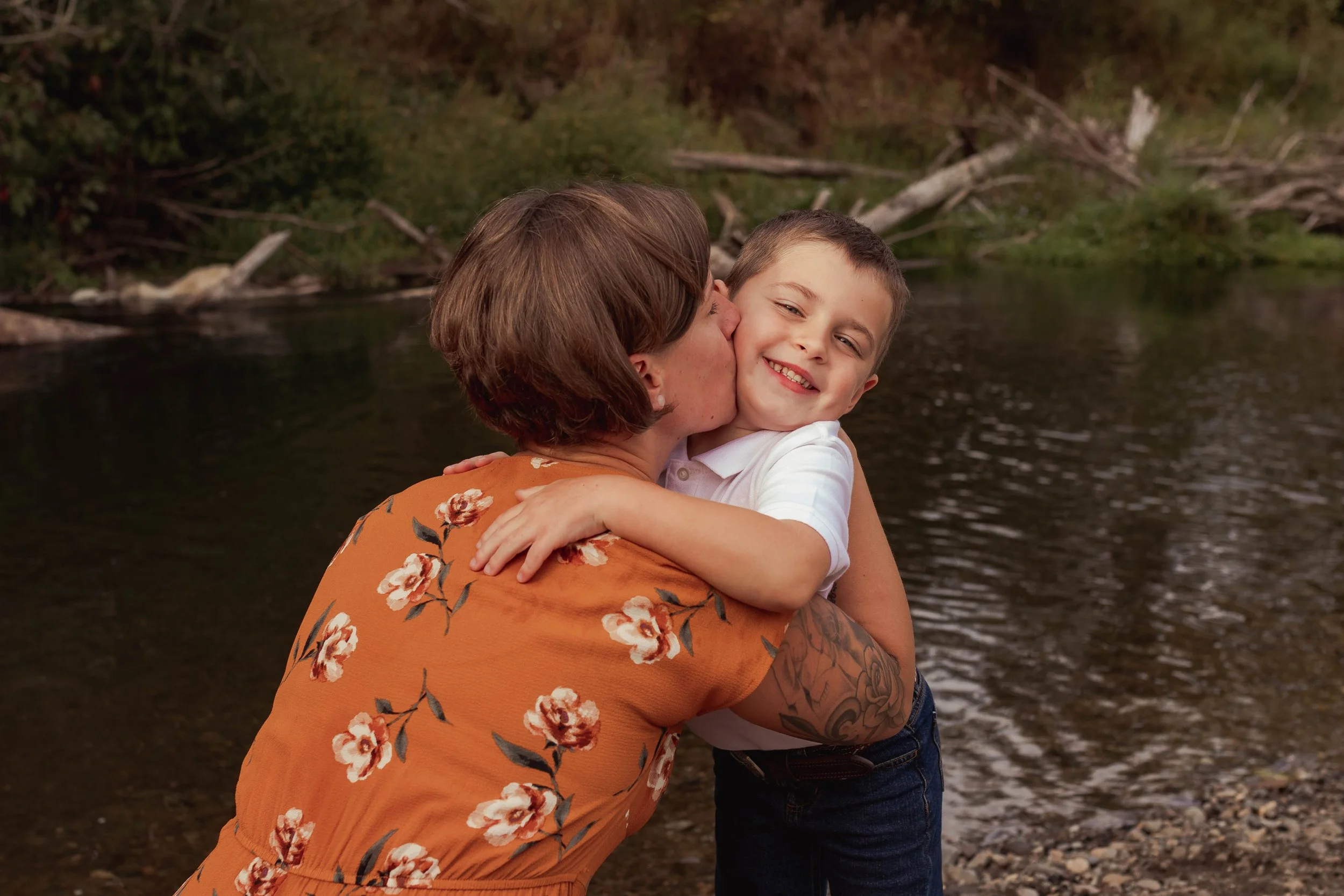 Mom embraces young son by the Deschutes river.  Pioneer Park family of 4 photoshoot.