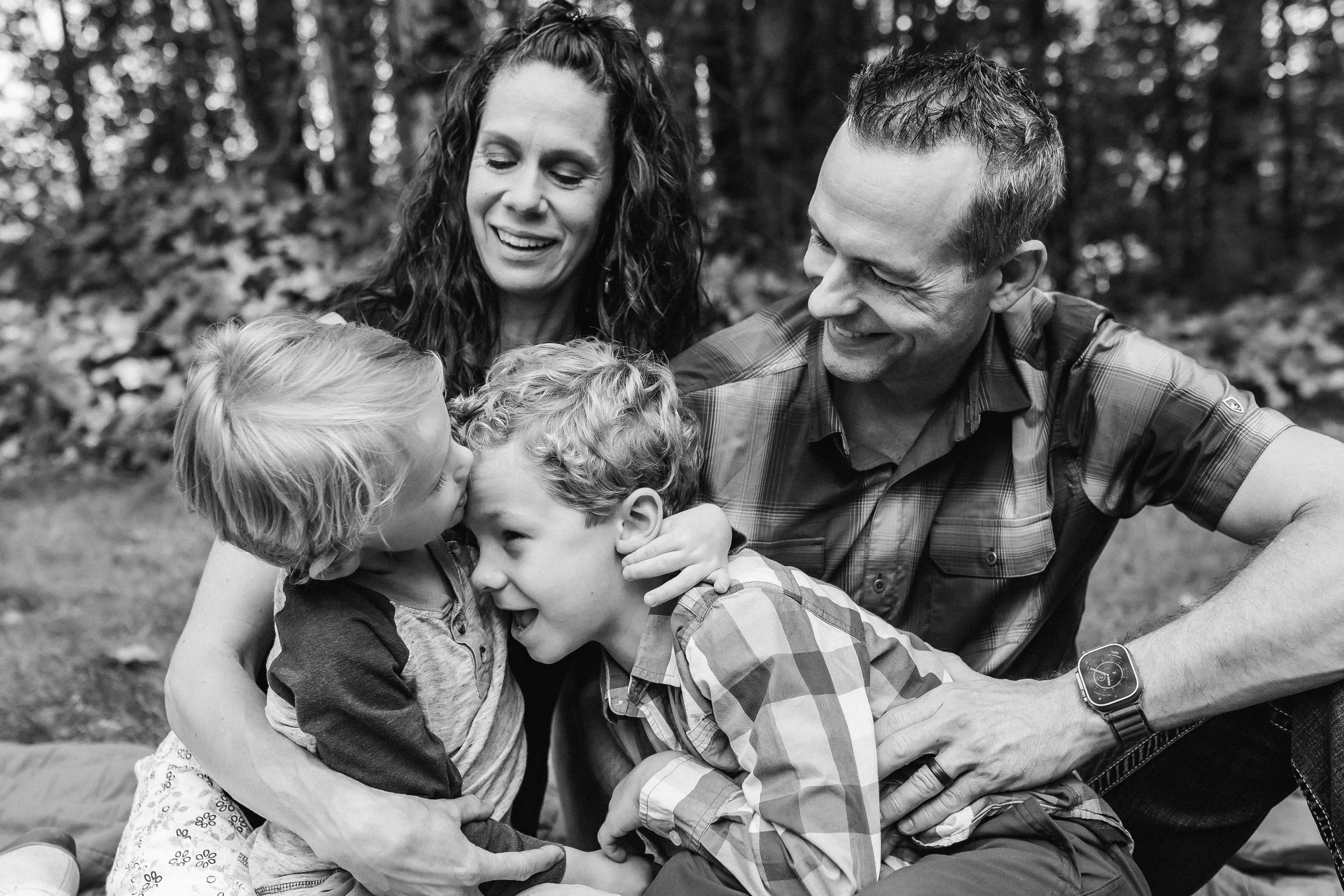 family of four lifestyle family photoshoot. Brothers give hugs and kisses. Olympia Washington family photographer. Portrait photographer. Senior photographer. Family photograph.