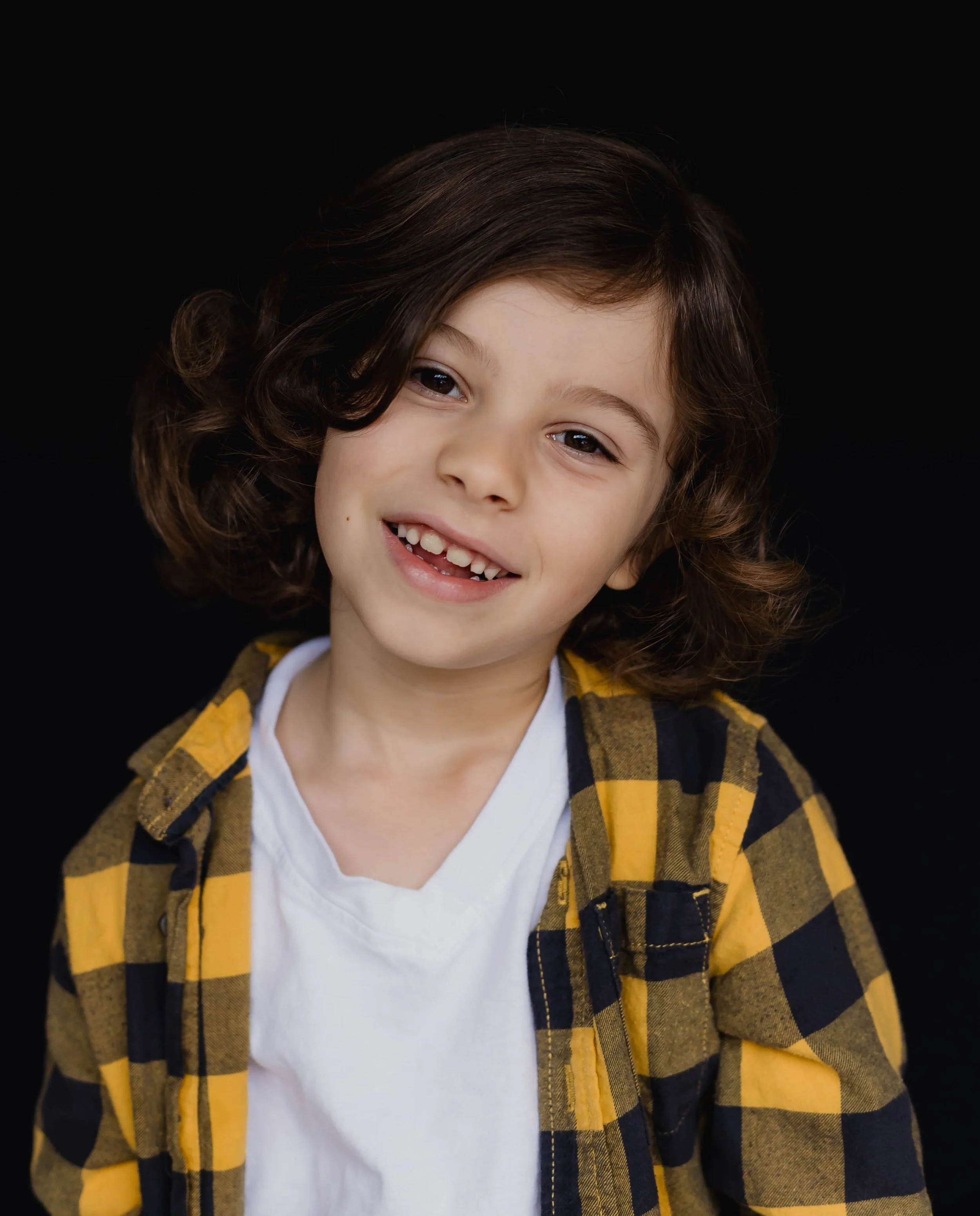 school portrait of young boy smiling in front of black background. Homeschool school kid portrait photographer in Olympia Washington.