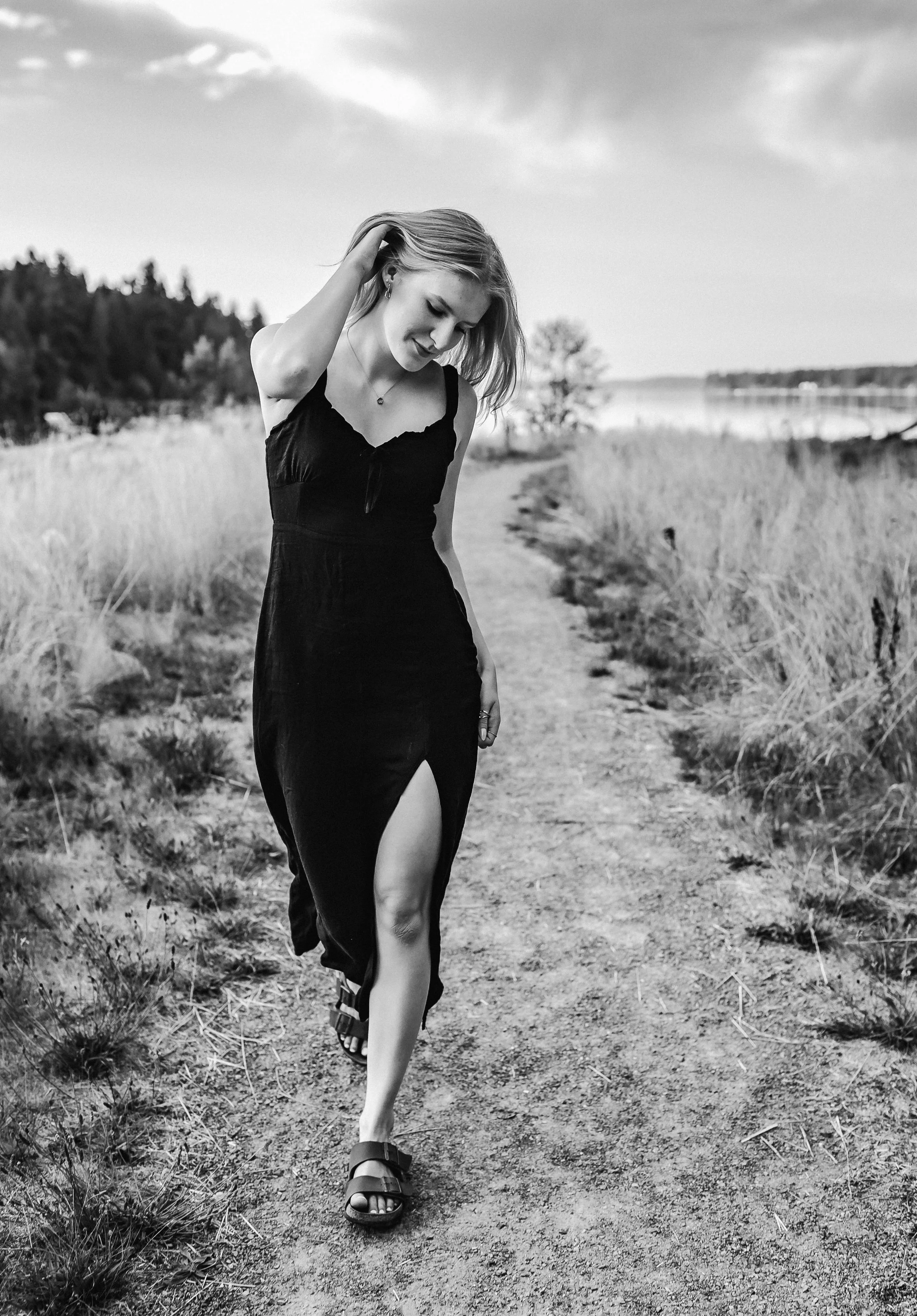 Portrait of a senior girl walking on the beach in a black dress during sunset at Woodard Bay.