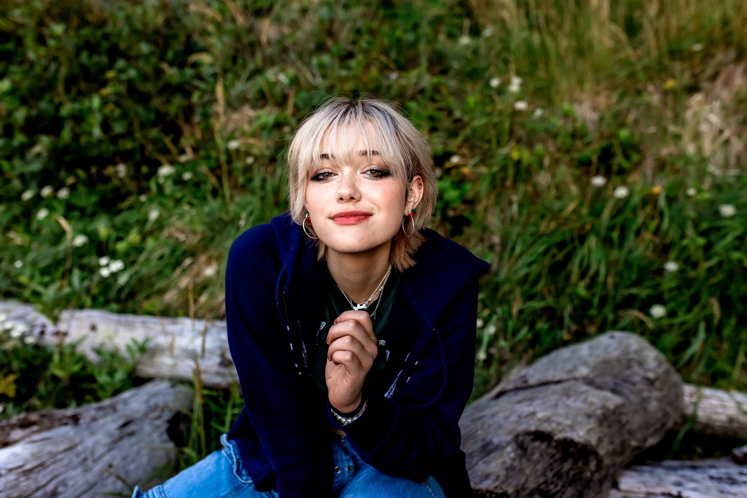 senior portrait. girl looking into camera. nature portraits. senior photographer located in olympia washington. tall beach grass. driftwood. teen fashion.