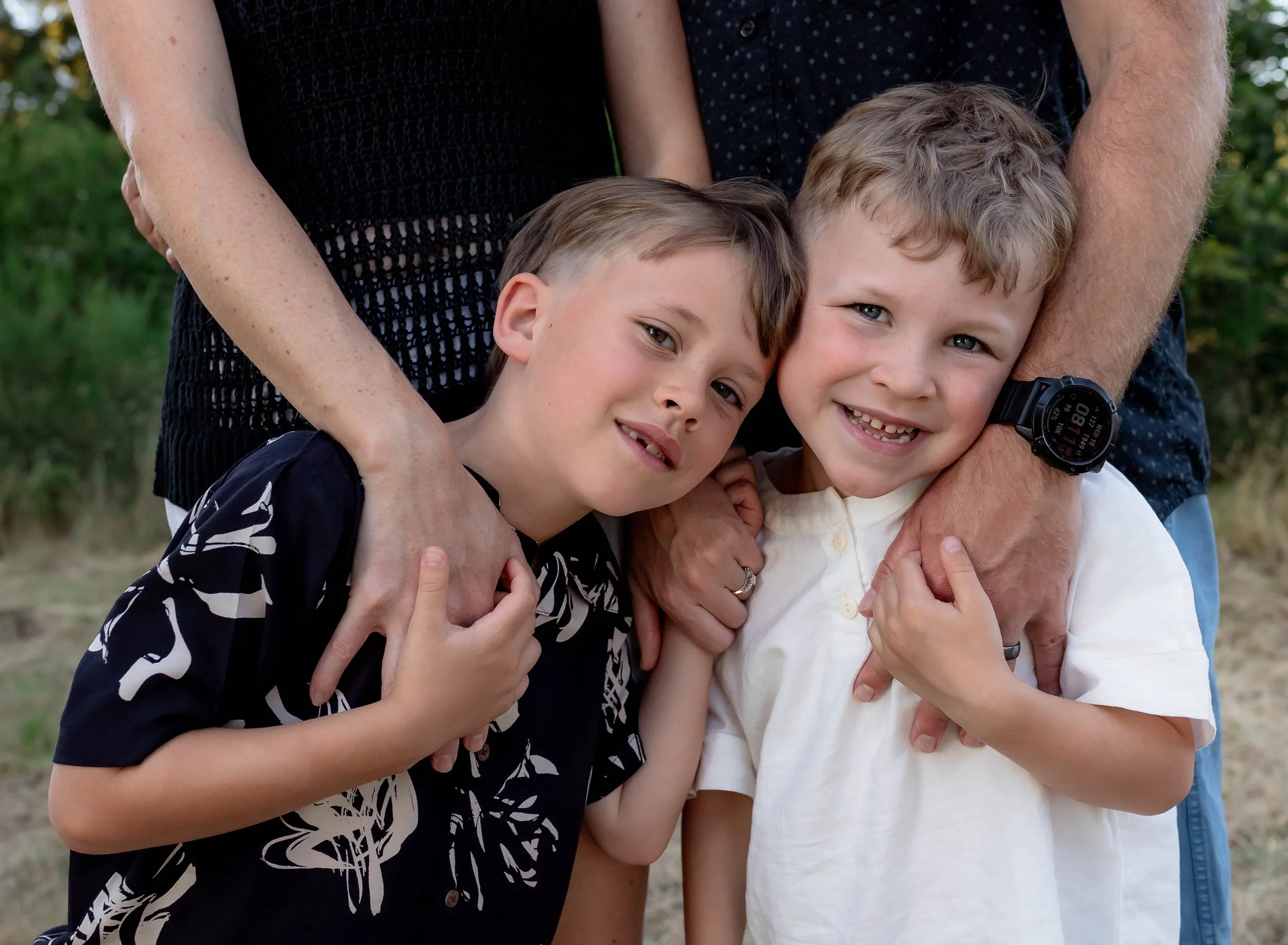 Family of four with two brothers embraced in mom and dad arms while snuggling. Olympia Washington family photographer.