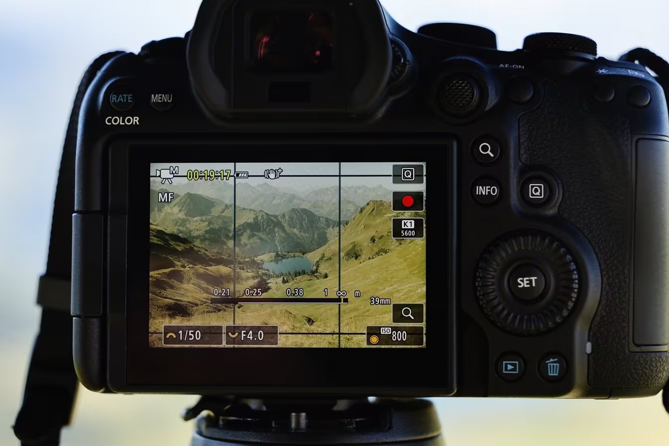 Canon EOS R6 Mark III Digital camera displaying a landscape scene of mountains and a lake on its LCD screen.