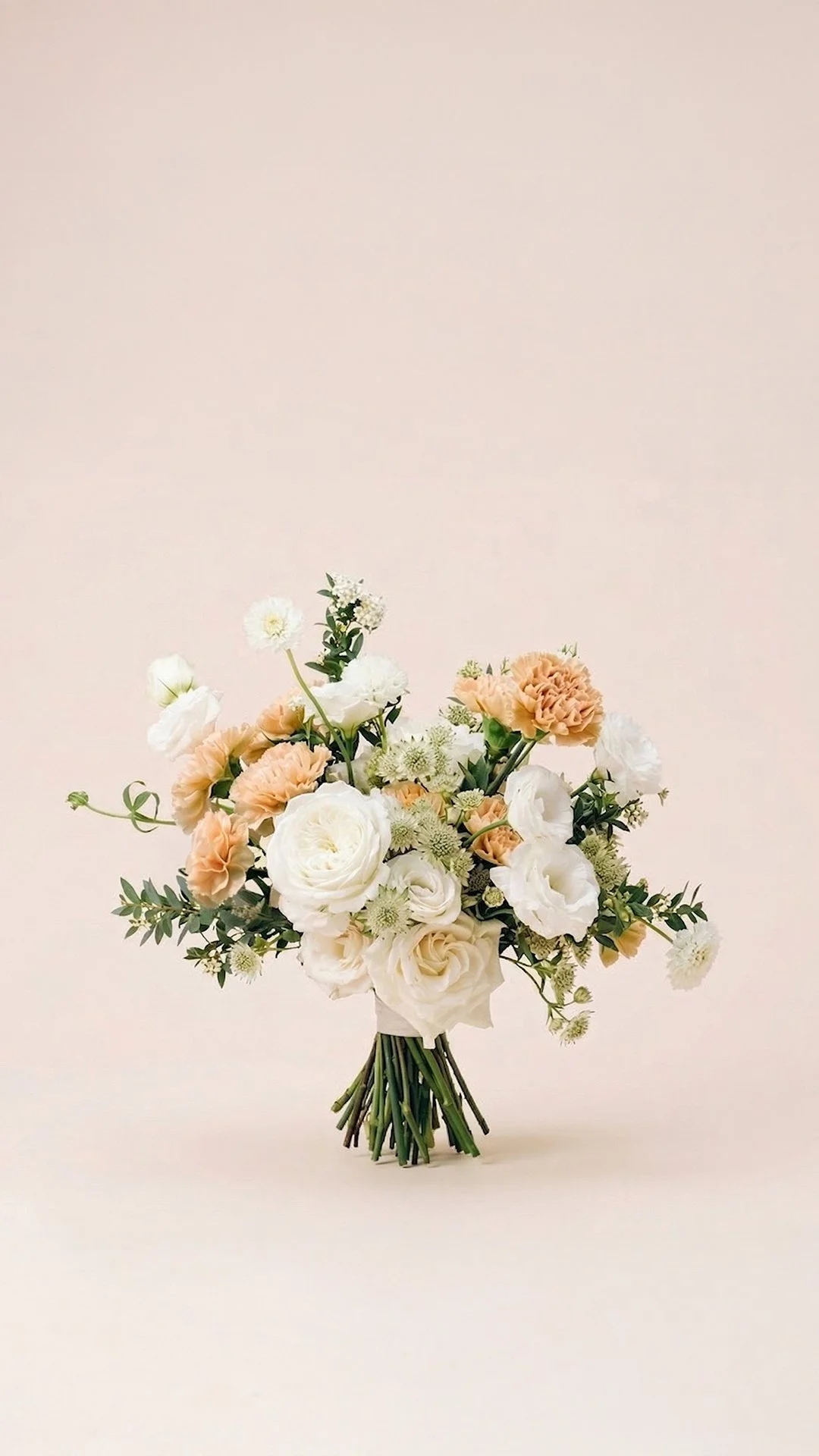A bouquet of white and peach flowers against a plain light background.