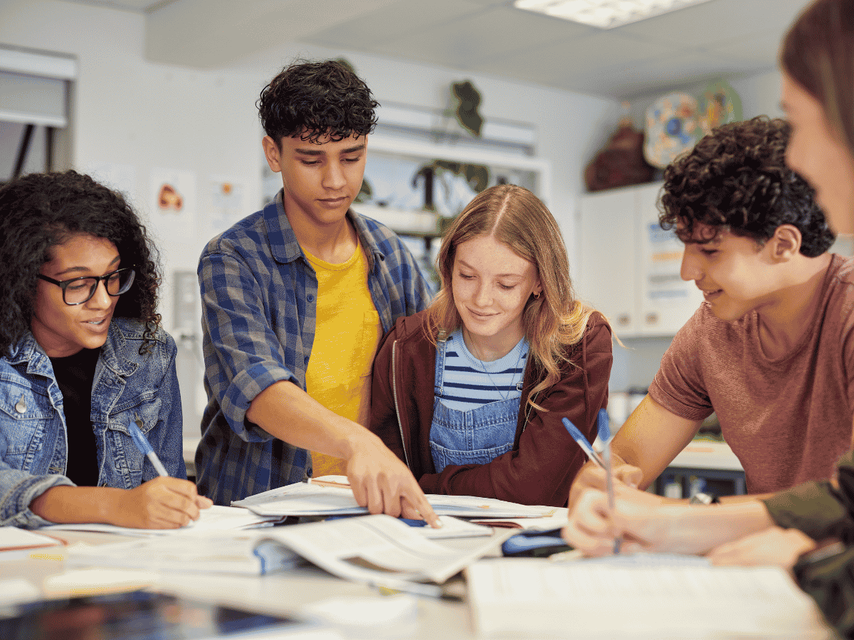 Students working together at a table in a classroom setting.