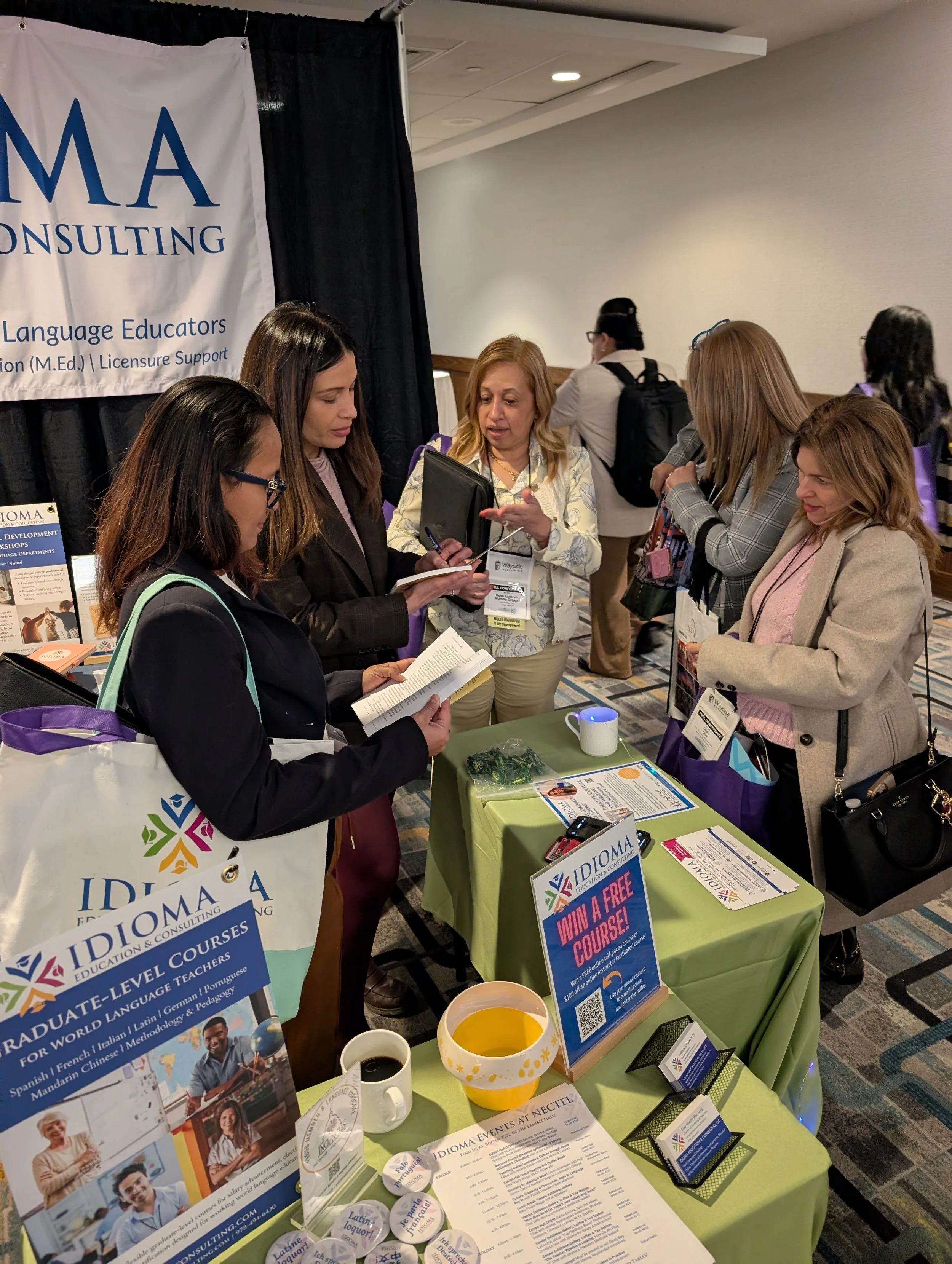 Alba Wagar smiles while signing a copy of her novel, El Despertar de Gabby, for an educator at the Idioma Education & Consulting booth during the NECTFL conference in Midtown Manhattan.
