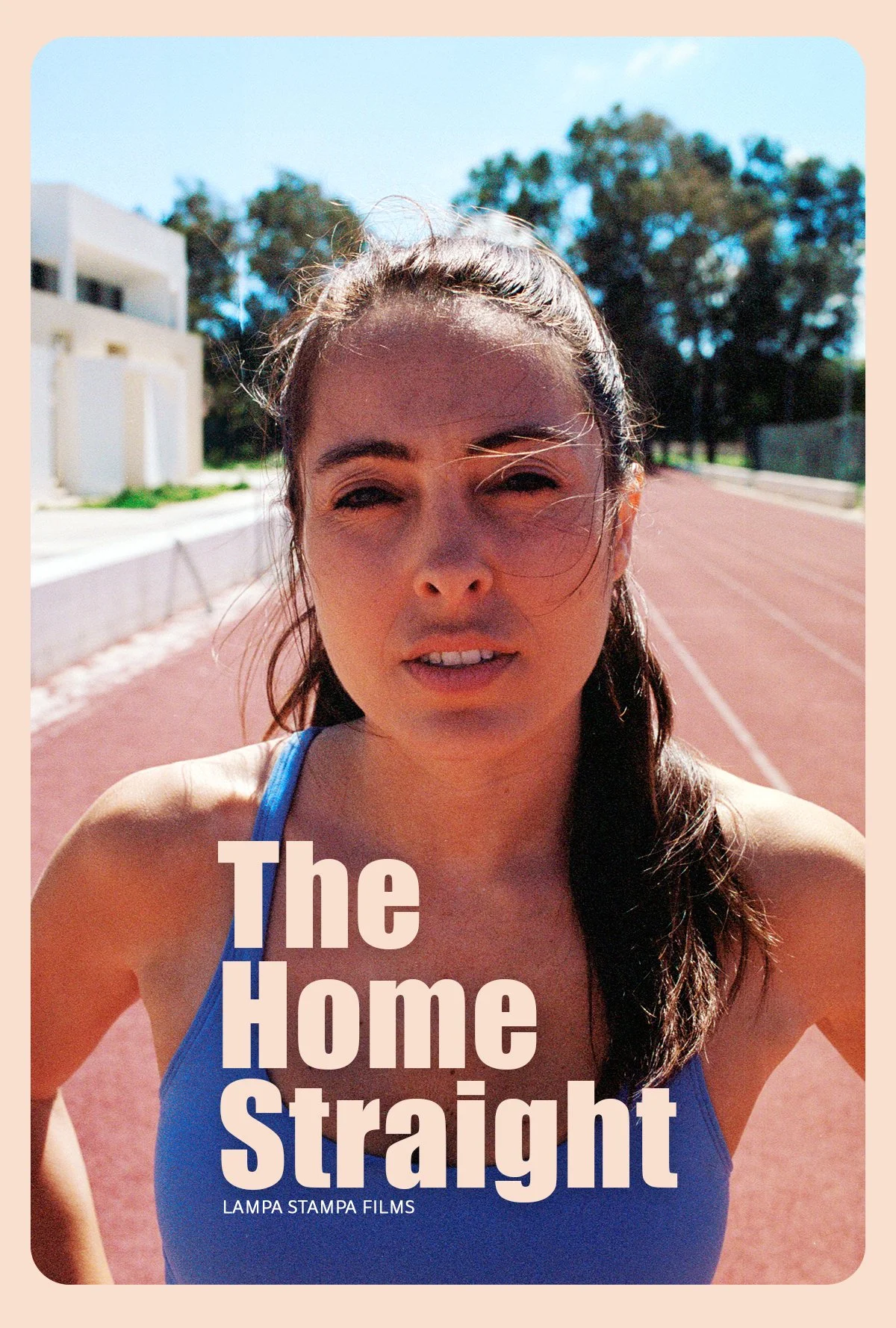 A woman in a blue athletic top standing on an outdoor running track on a sunny day with trees and buildings in the background. Text on the image reads "The Home Straight" and "Lampa Stampa Films."