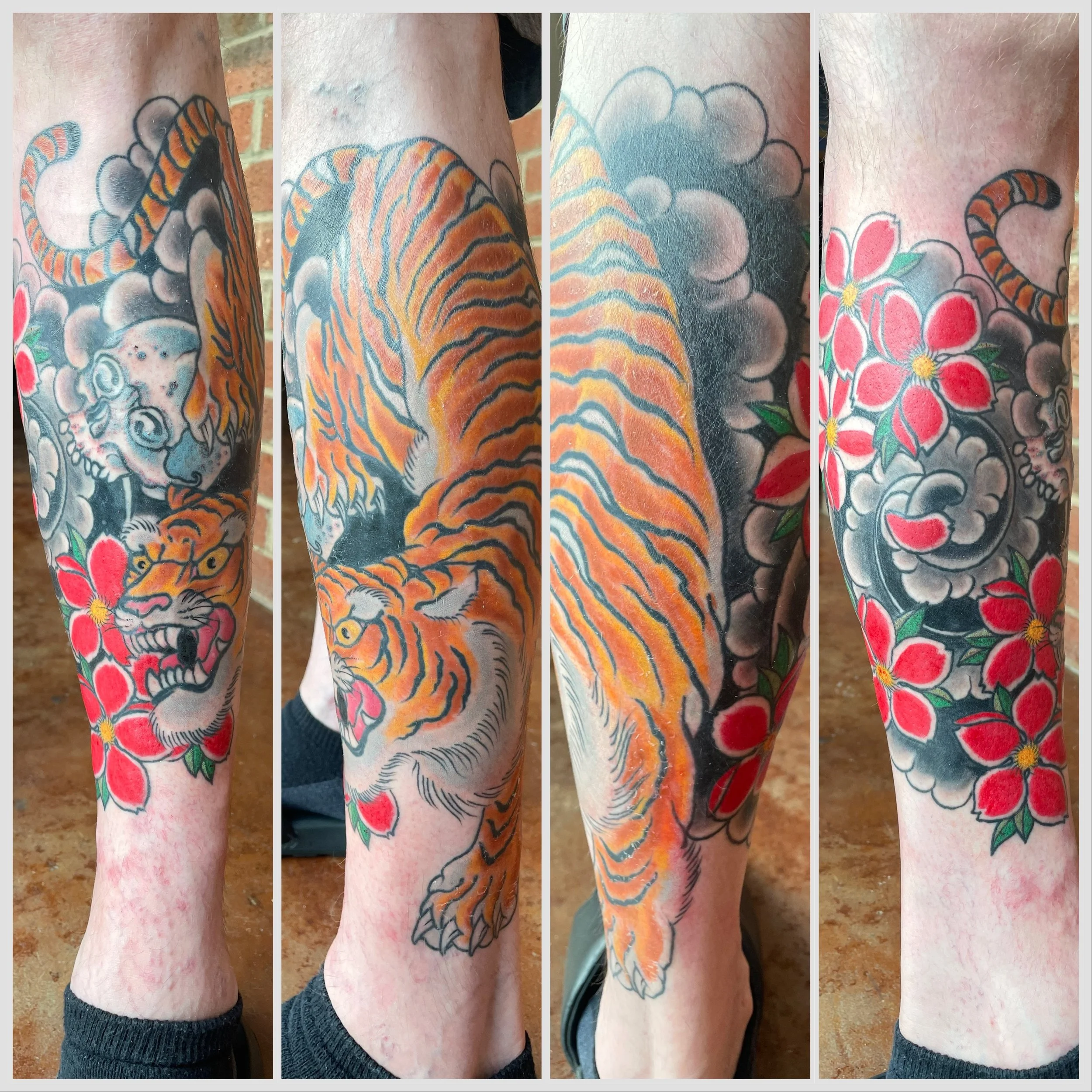 Tattoo of a tiger and colorful flowers on person's leg.