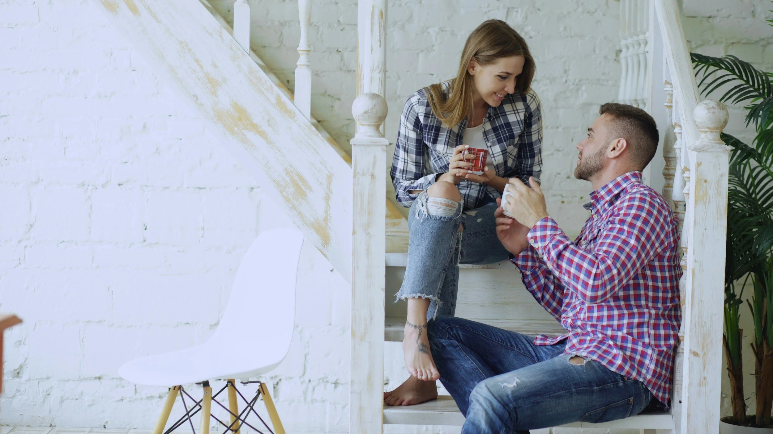 partners having coffee and laughing together in a warm, everyday home setting