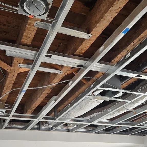 Exposed ceiling framing during water damage drywall restoration in Miami building