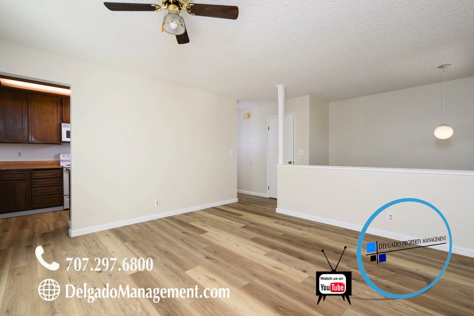 Empty living room with wooden floors, ceiling fan, and visible kitchen area, with overlay text including contact information and branding for Delgado Property Management.