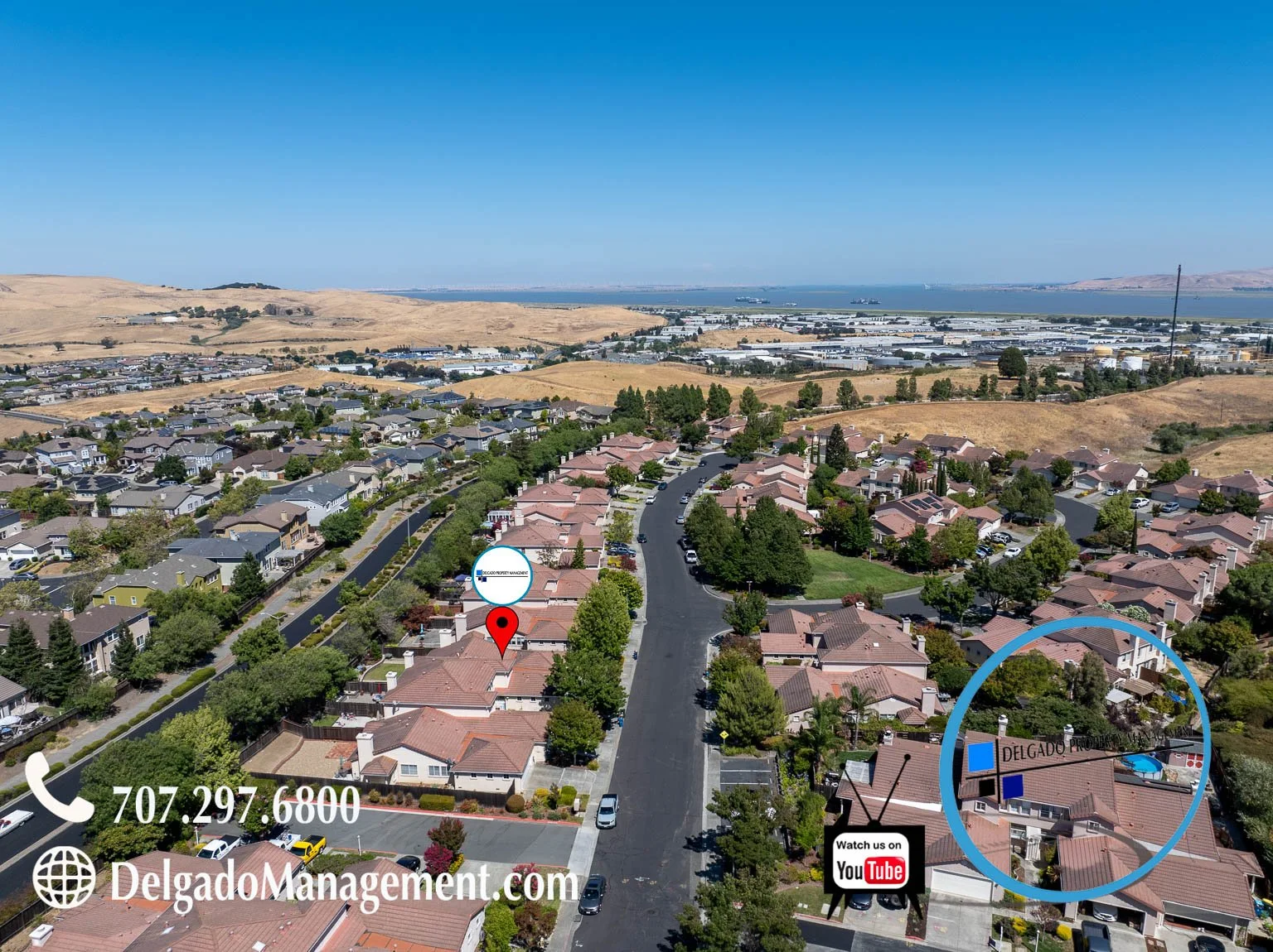 Aerial view of a suburban neighborhood with residential houses, a curved street, trees, and a distant shoreline with industrial buildings. Overlay text includes a phone number, website URL DelgadoManagement.com, and a YouTube logo.