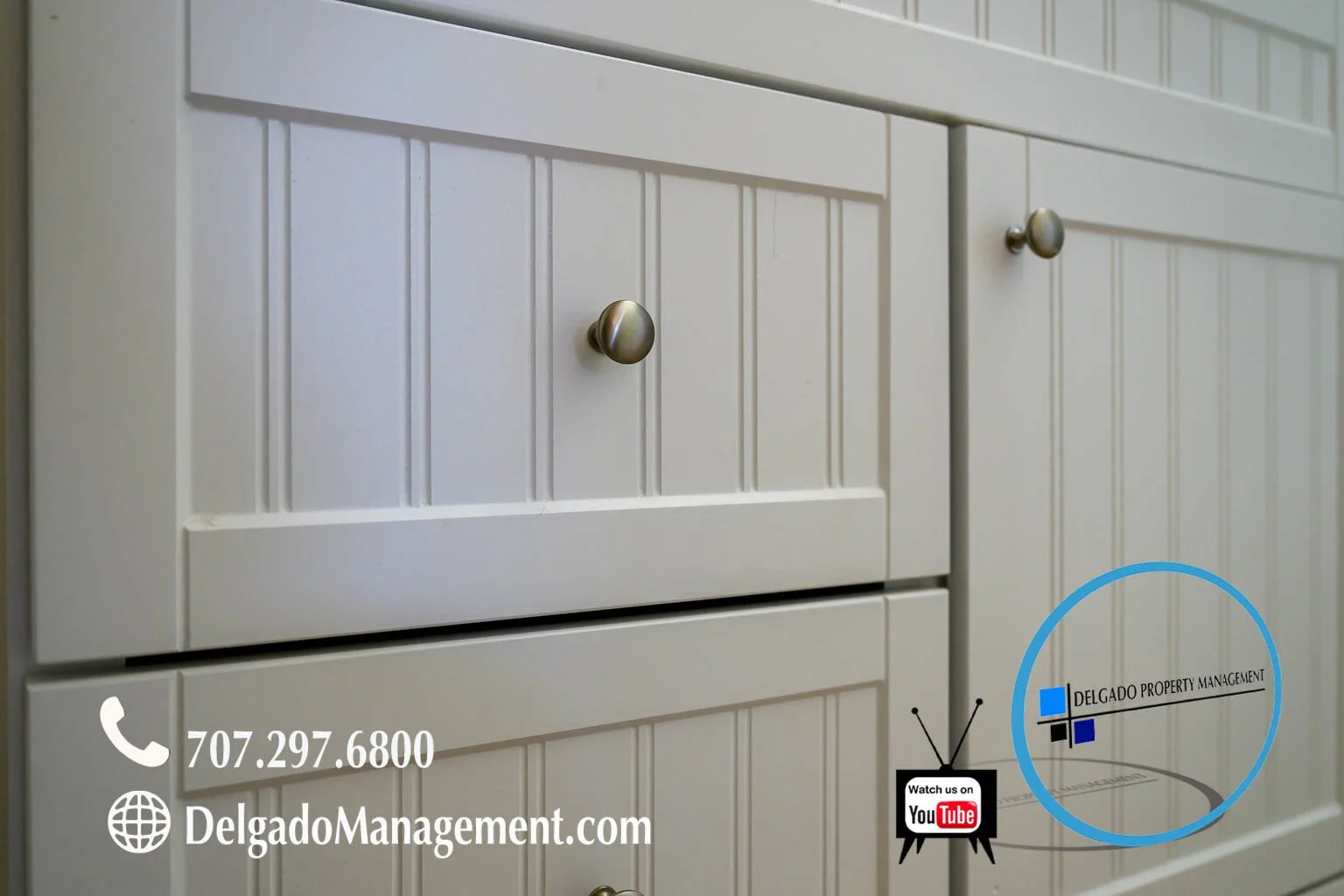 Close-up of white pantry cabinets with metallic knobs, with a company logo and contact information for Delgado Property Management and a YouTube icon on the lower right side.