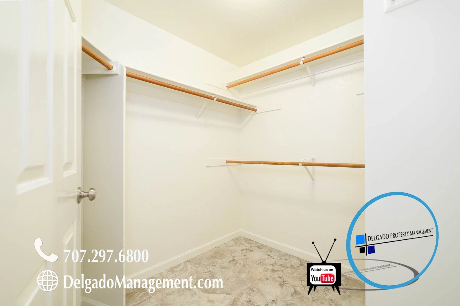 Empty walk-in closet with white walls, a door, and wooden closet rods on metal brackets, a tiled floor, and a Delgato Property Management logo and contact information in the corner.