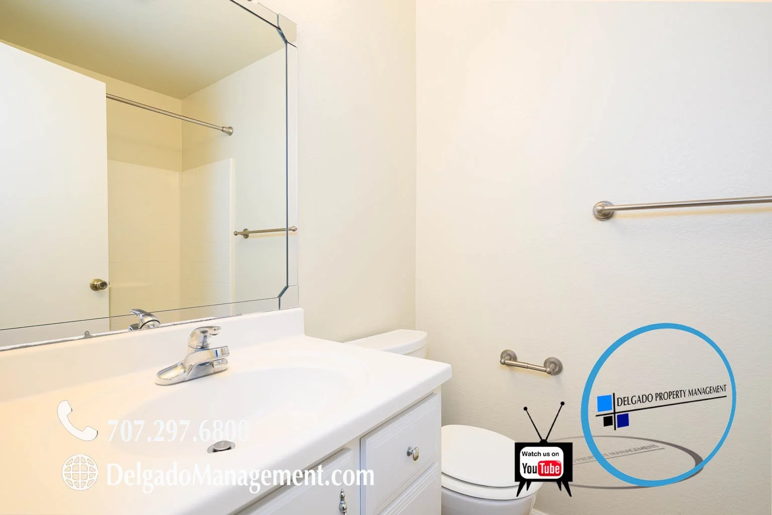 Bathroom with a white vanity, sink, mirror, toilet, and two metal towel bars on the wall. There are promotional graphics for Delgado Property Management and YouTube at the bottom right corner of the image.