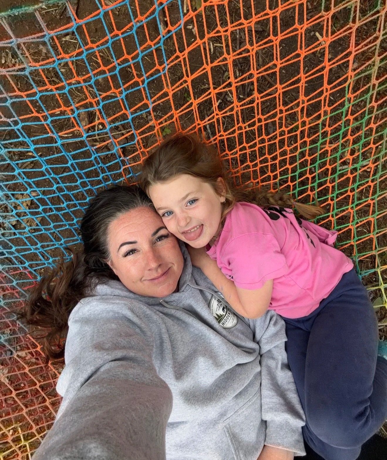 April and Abby Gihring laying in a hammock at Hidden Trails Forest and Farm School in Enumclaw Washington.