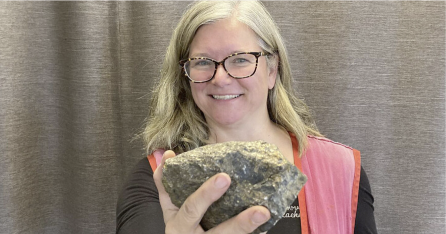 Pharmacist holding a large rock