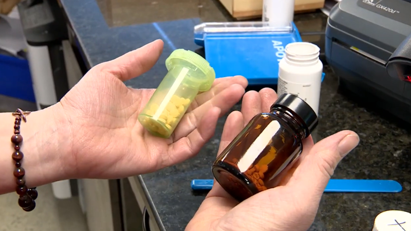 Hands holding pharmacy pill bottles