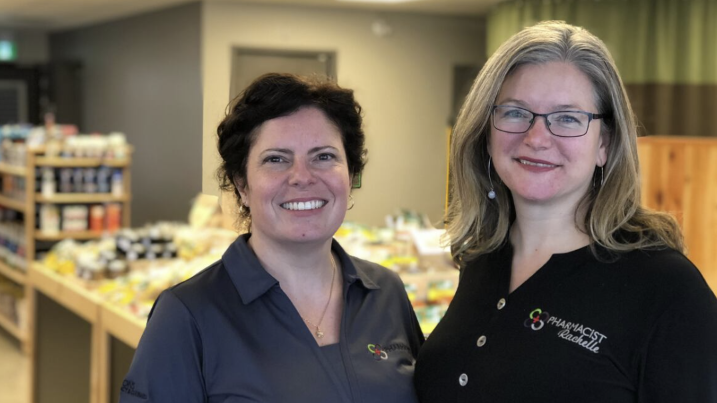 Two pharmacists smiling in the pharmacy