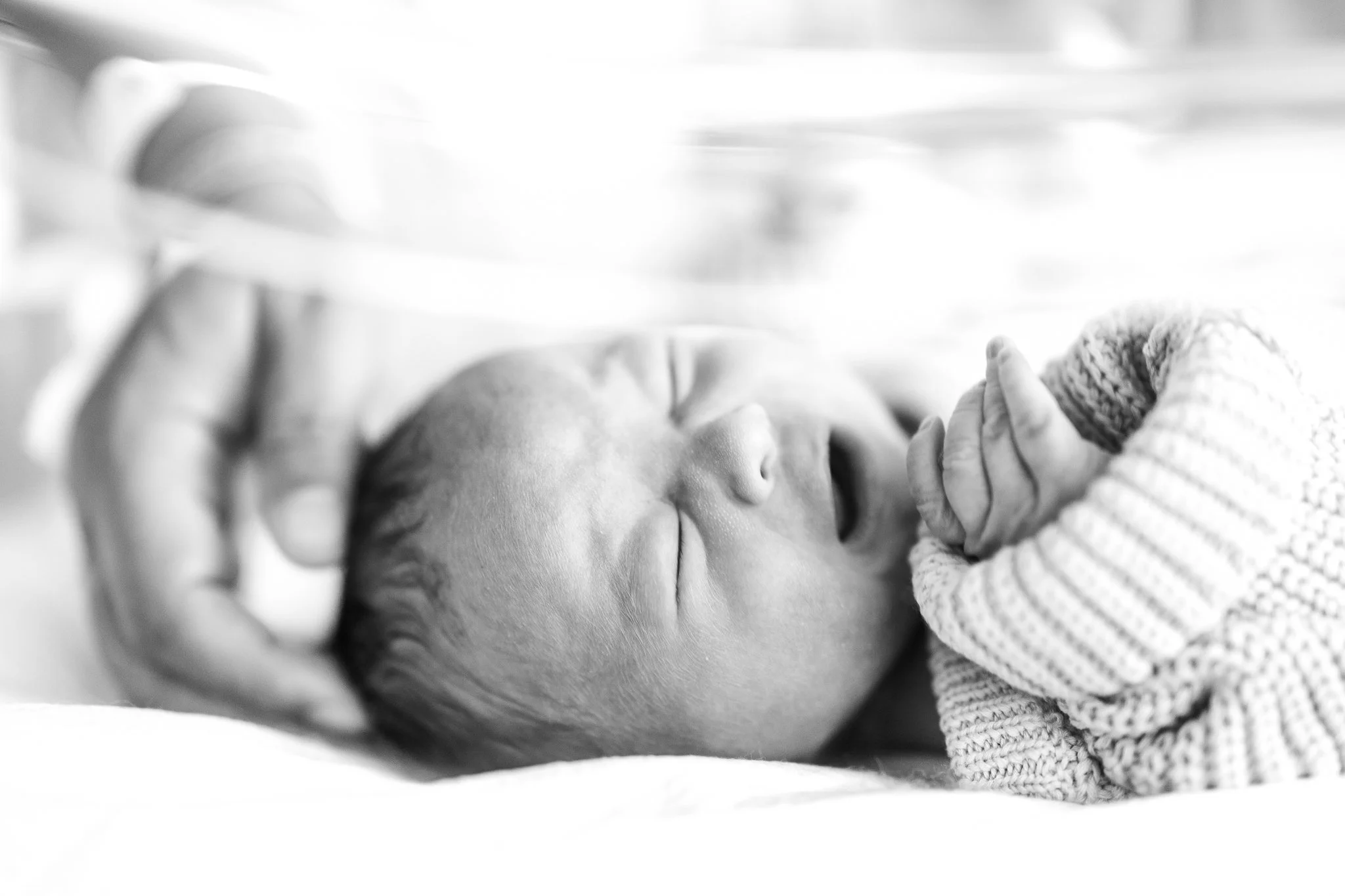 mom caressing and soothing newborn baby in the hospital after birth 
