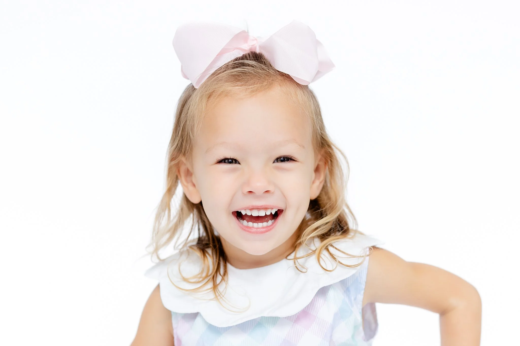 Smiling girl with pink bow and dress