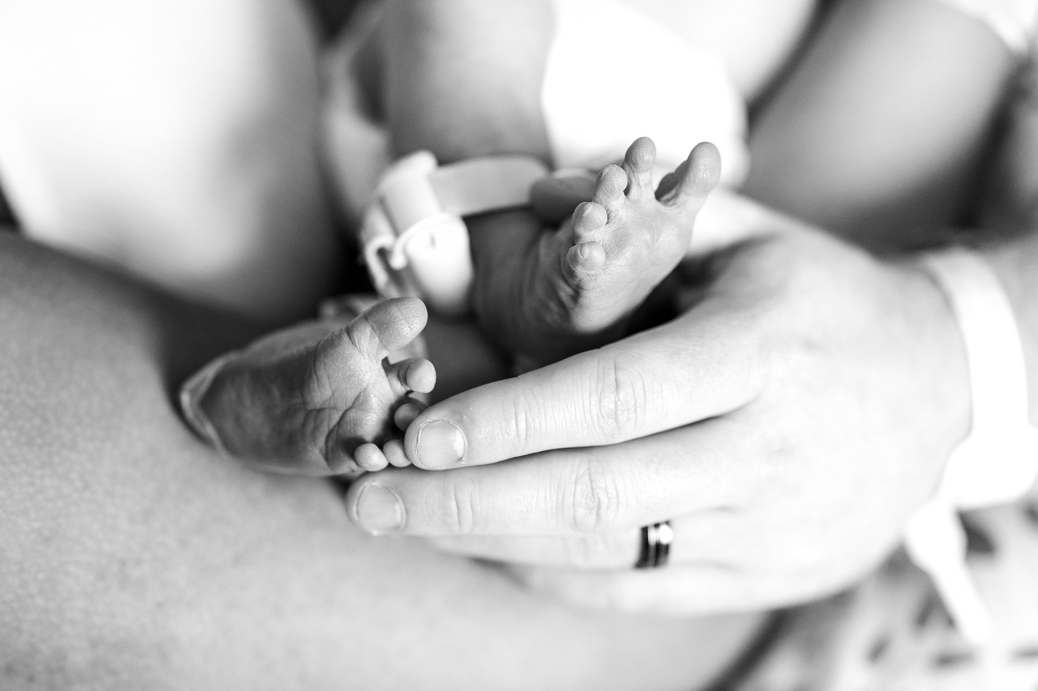 dad holding newborn baby feet 48 hours after birth in memphis tn 