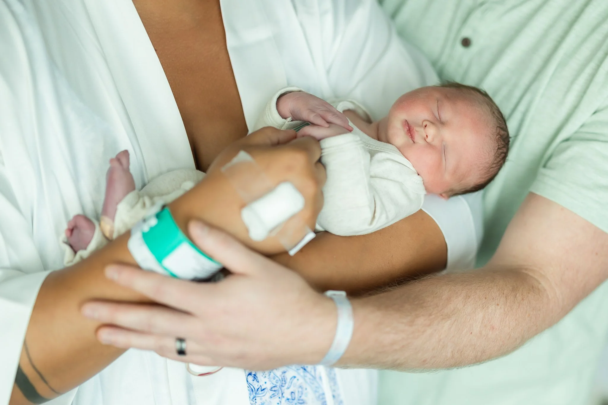 mom and dad holding baby close in the hospital room after birth in memphis 