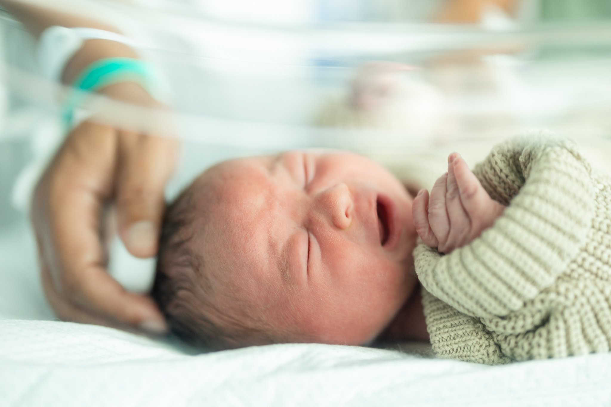 newborn baby boy in hospital bassinet