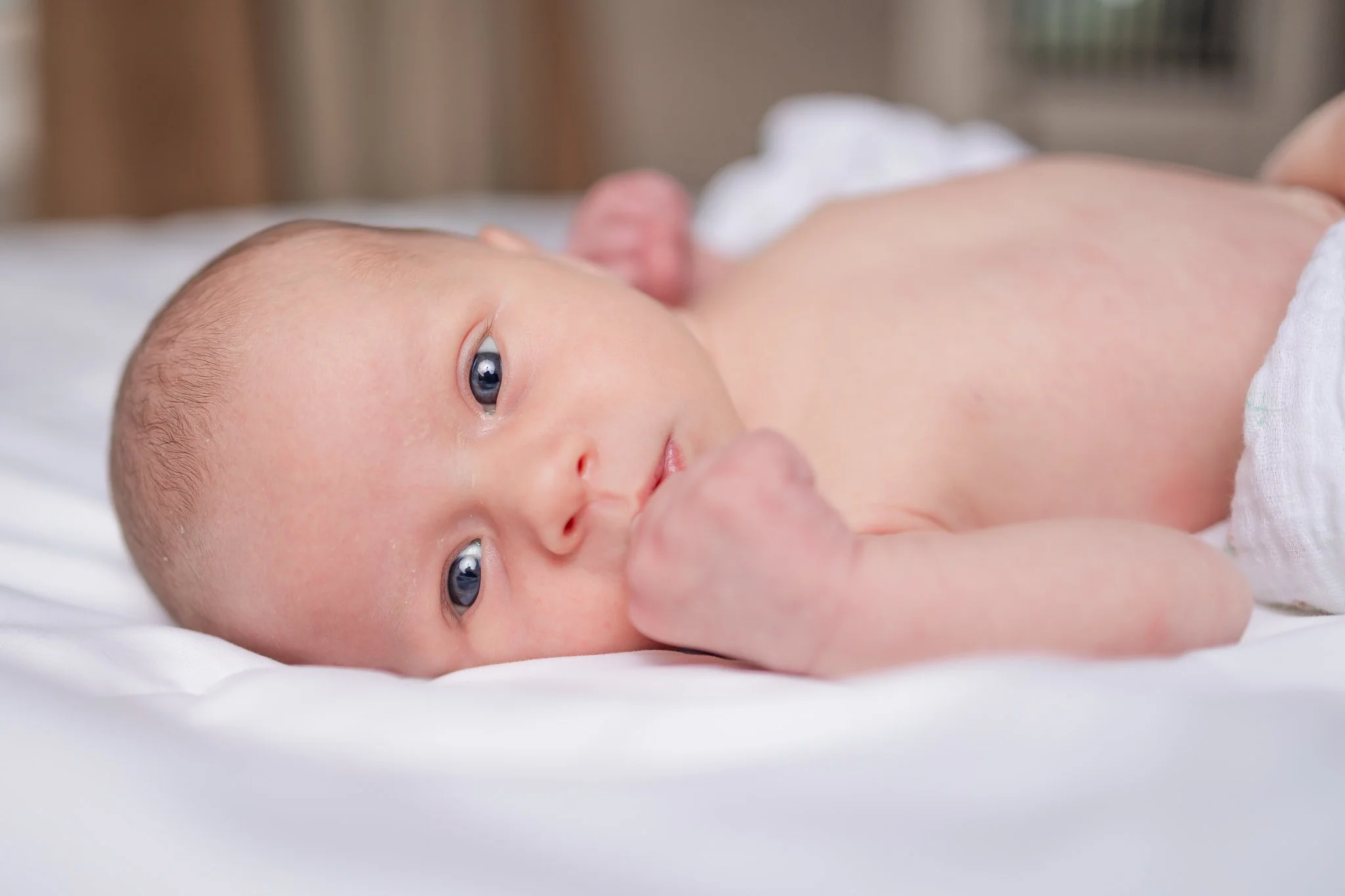 Newborn baby lying on white blanket