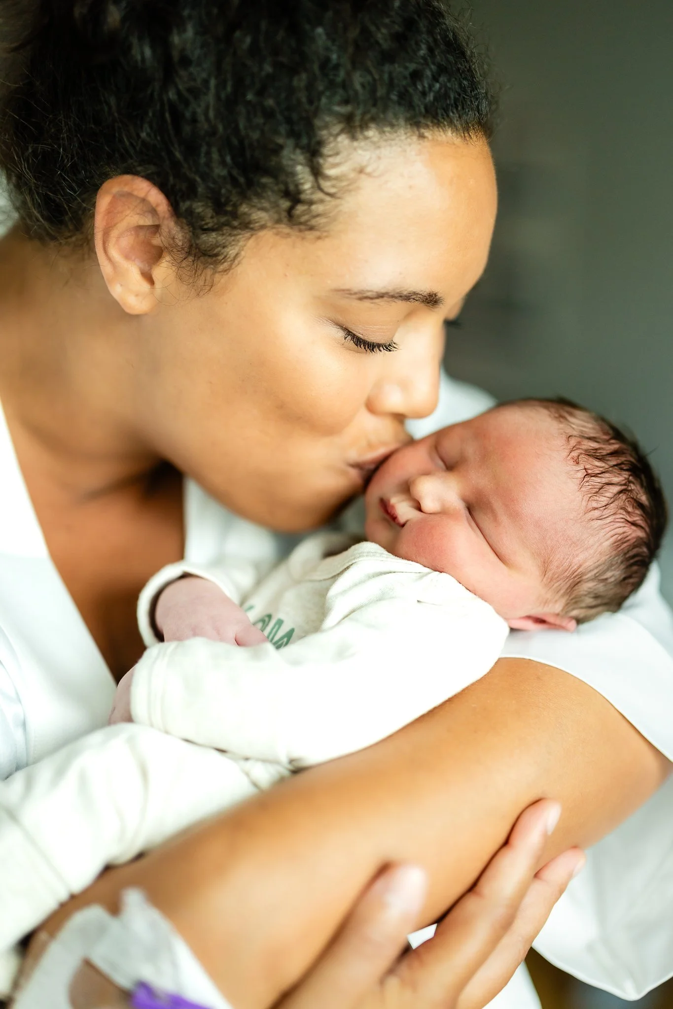 mom kissing her newborn son 