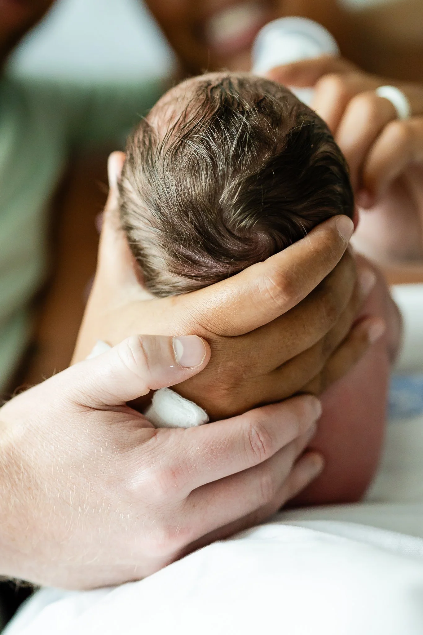 mom and dad holding baby close in the hospital room after birth in memphis 