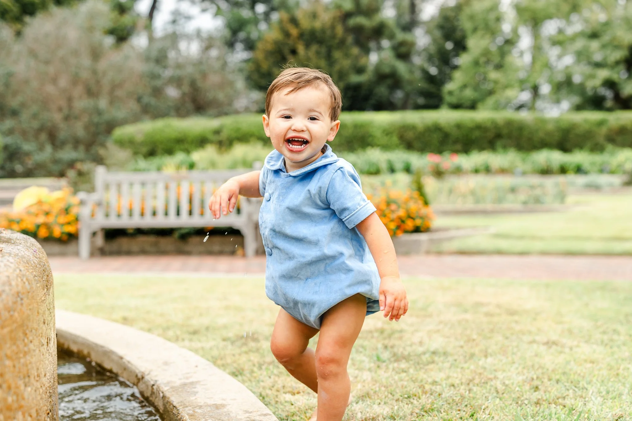 Little boy playing in water fountain at Botanic Gardens during a Family Photography session using Natural Light by Caitlin Ross in Memphis Tennessee