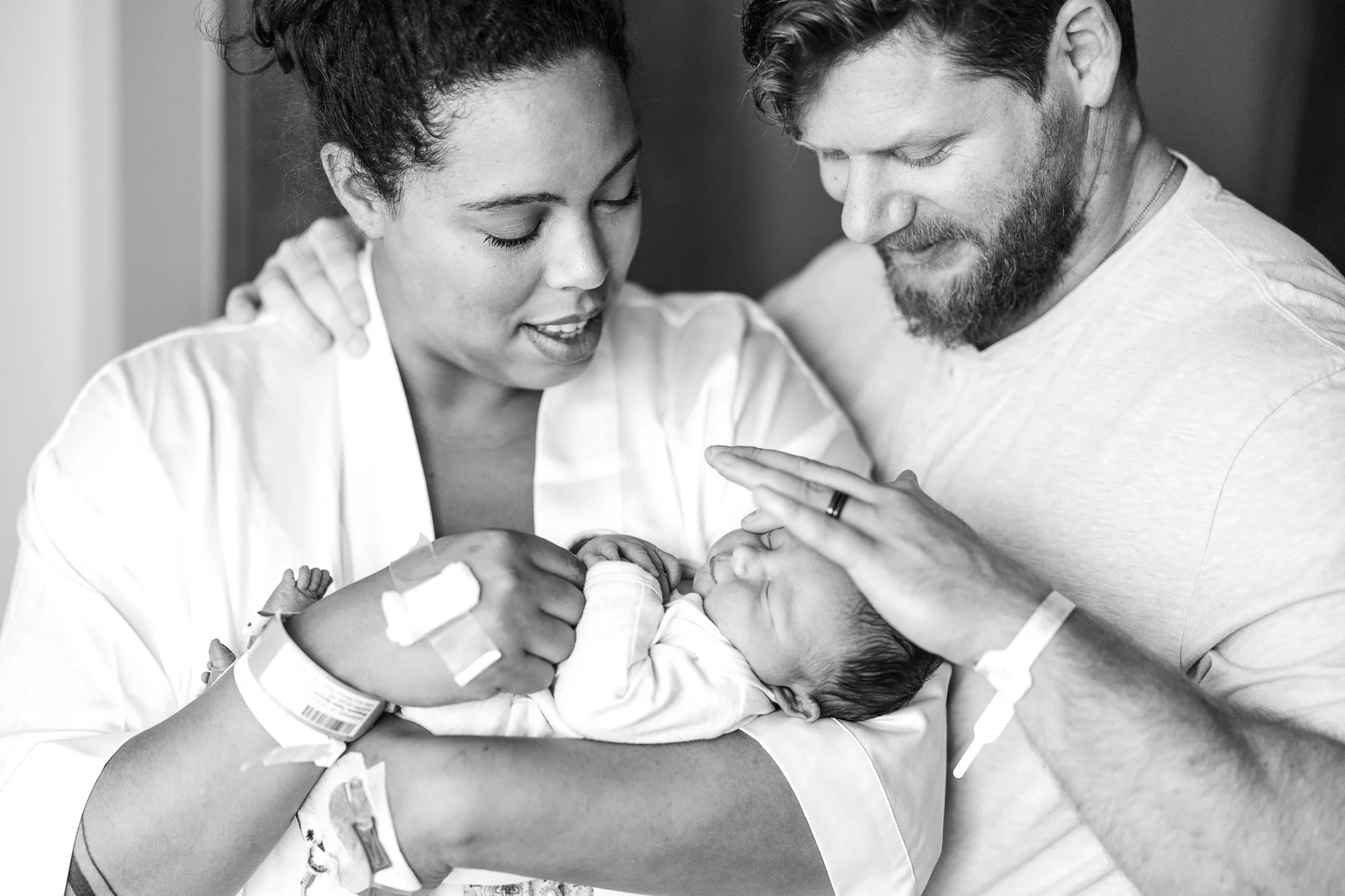 mom and dad holding baby close in the hospital room after birth in memphis 