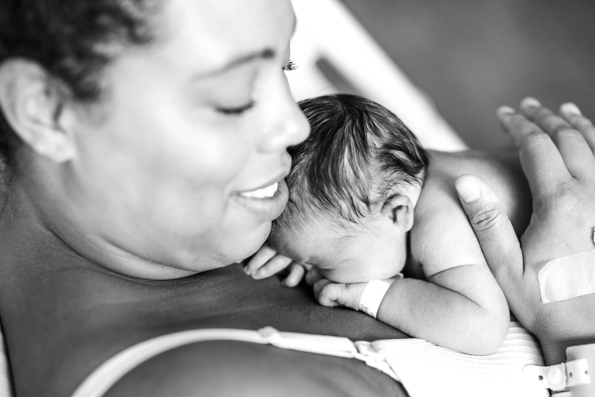 mom holding baby close and soothing him in the hospital room after birth in memphis 