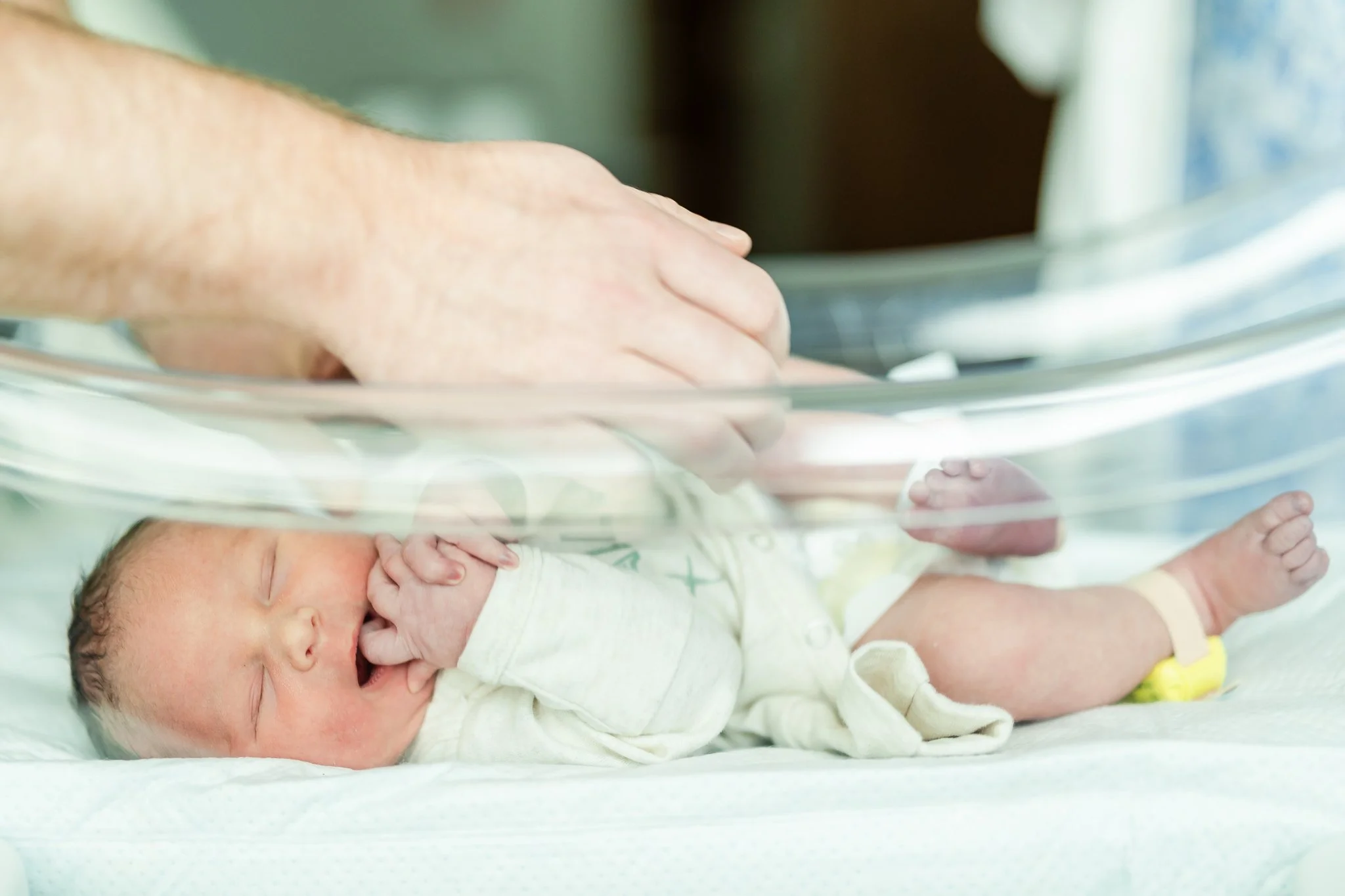 newborn baby boy in hospital bassinet