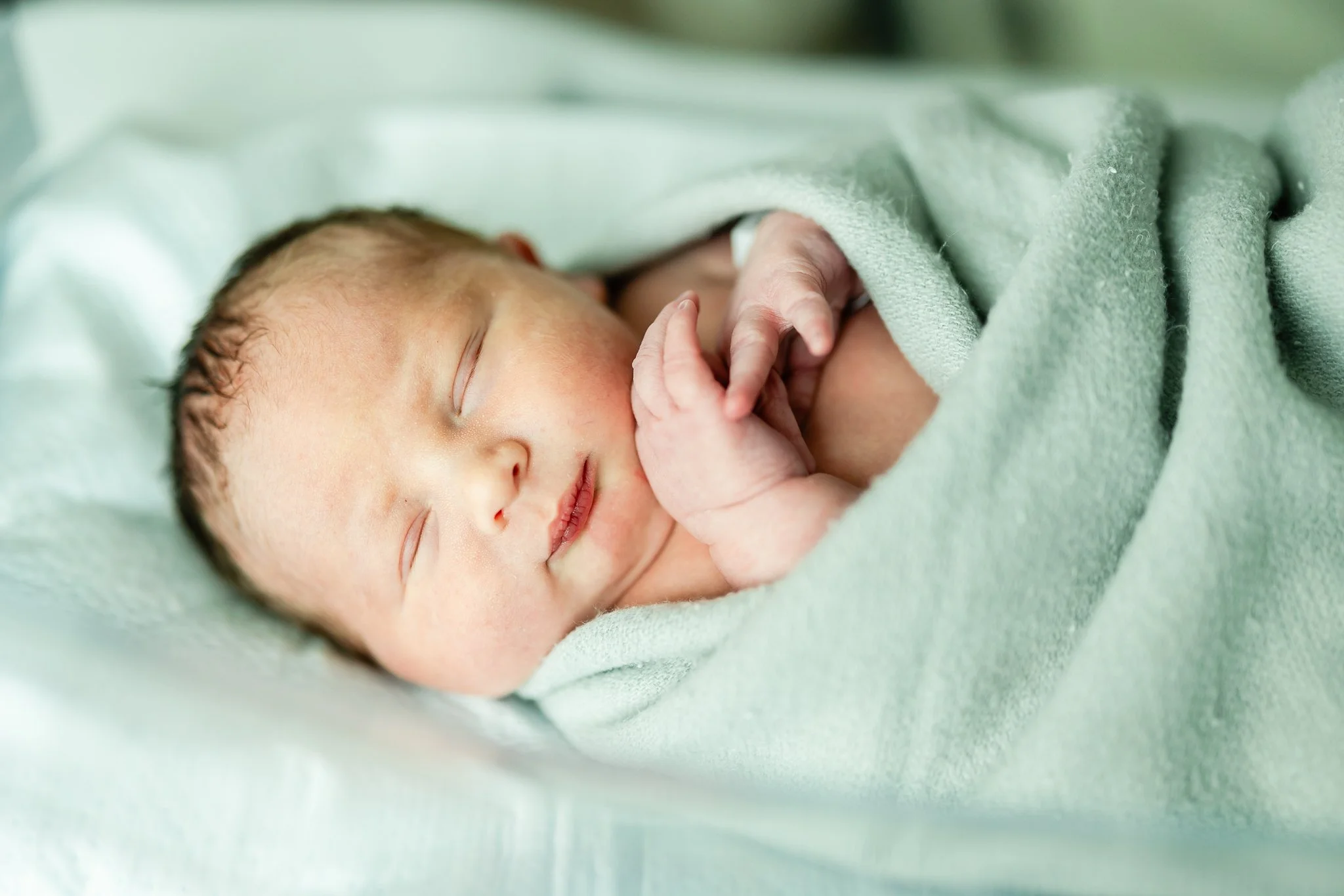 swaddled newborn baby boy in the hospital after birth