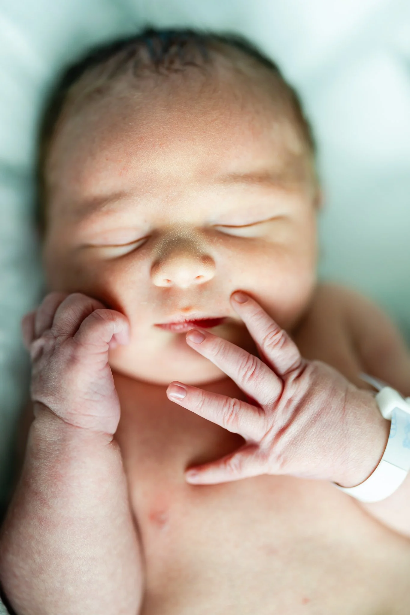 newborn baby boy with hand on his mouth  In memphis hospital after birth 