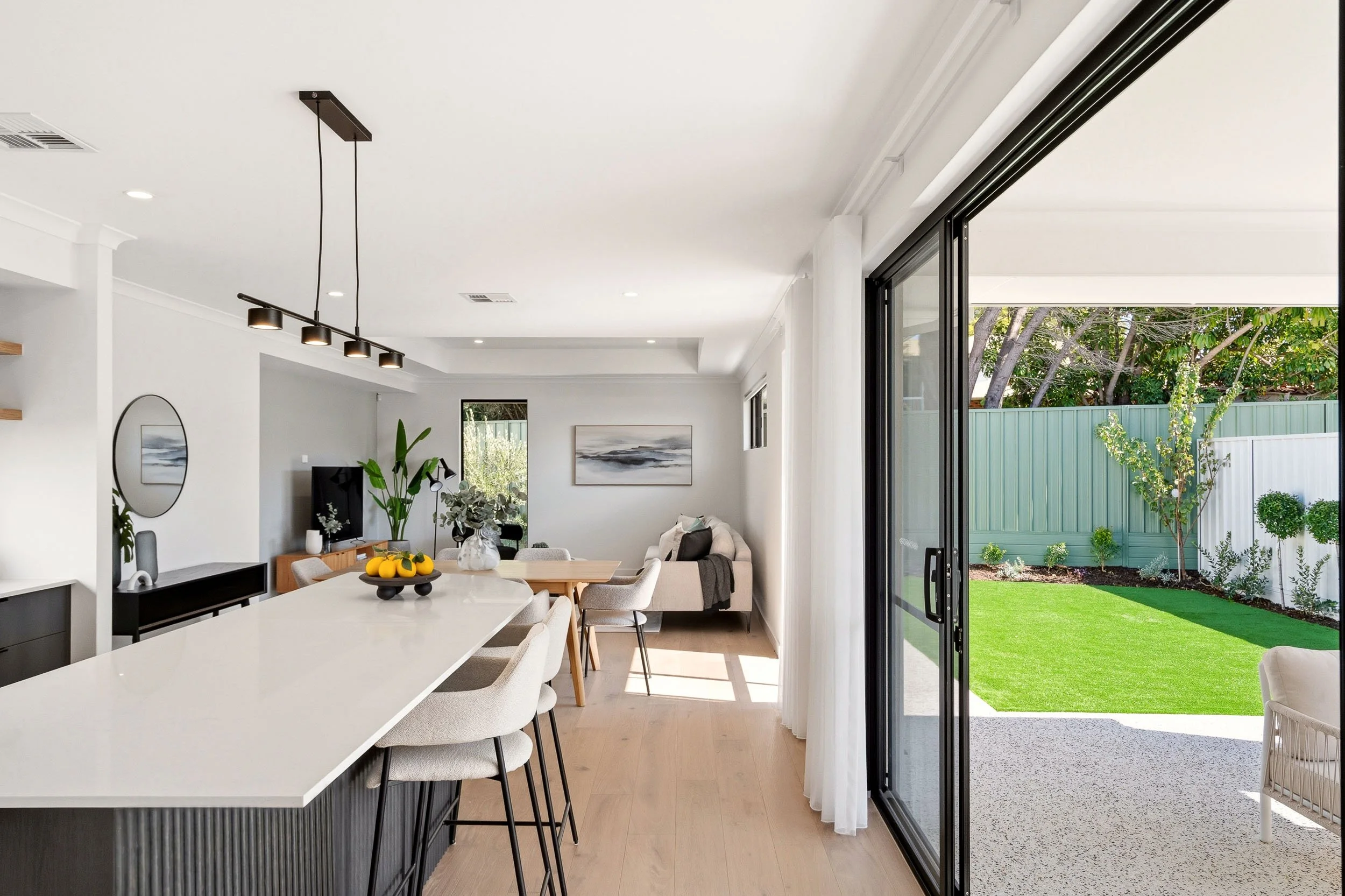 Kitchen and dining area opening through large sliding glass doors to the garden.