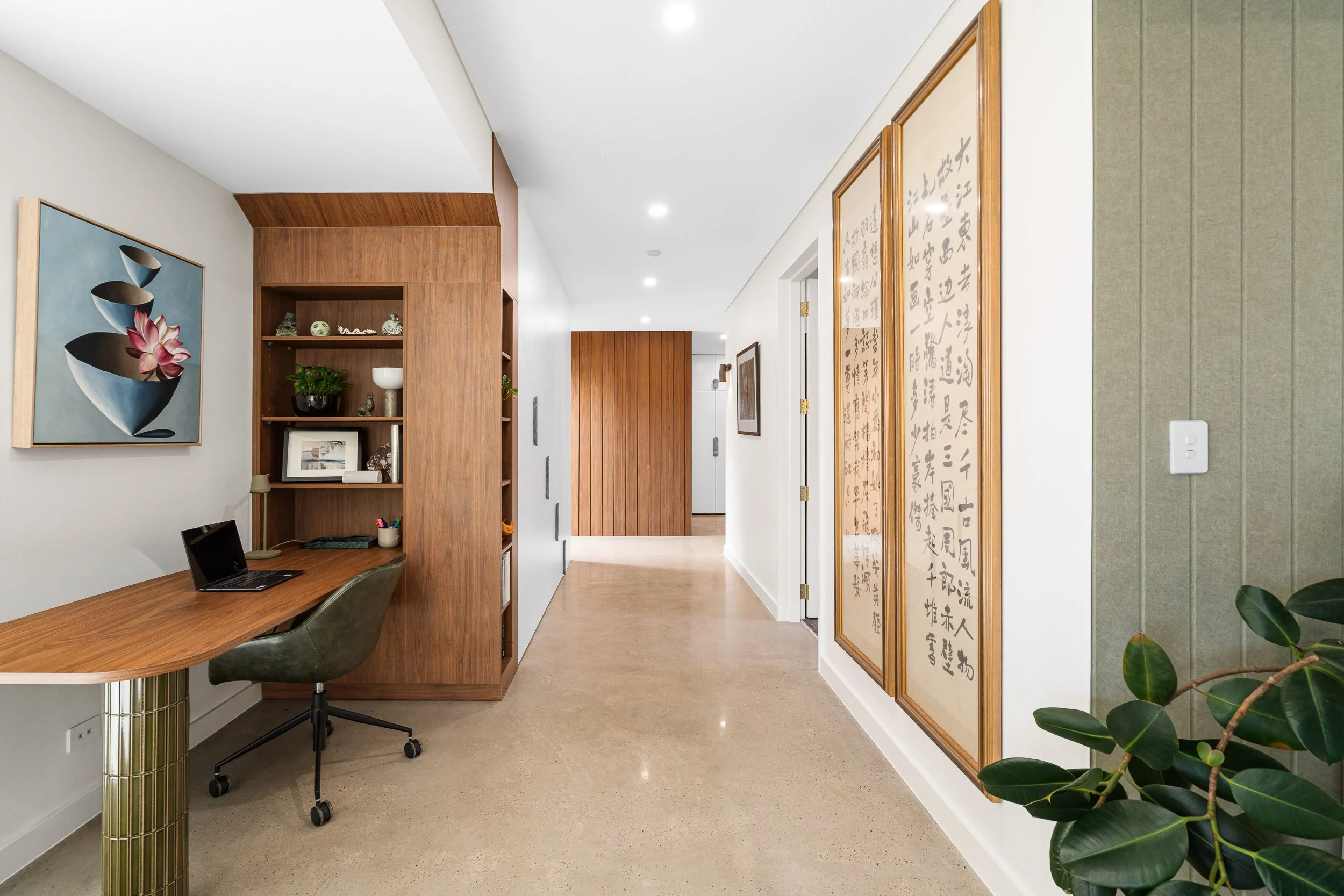 Hallway lined with timber joinery and framed calligraphy panels.