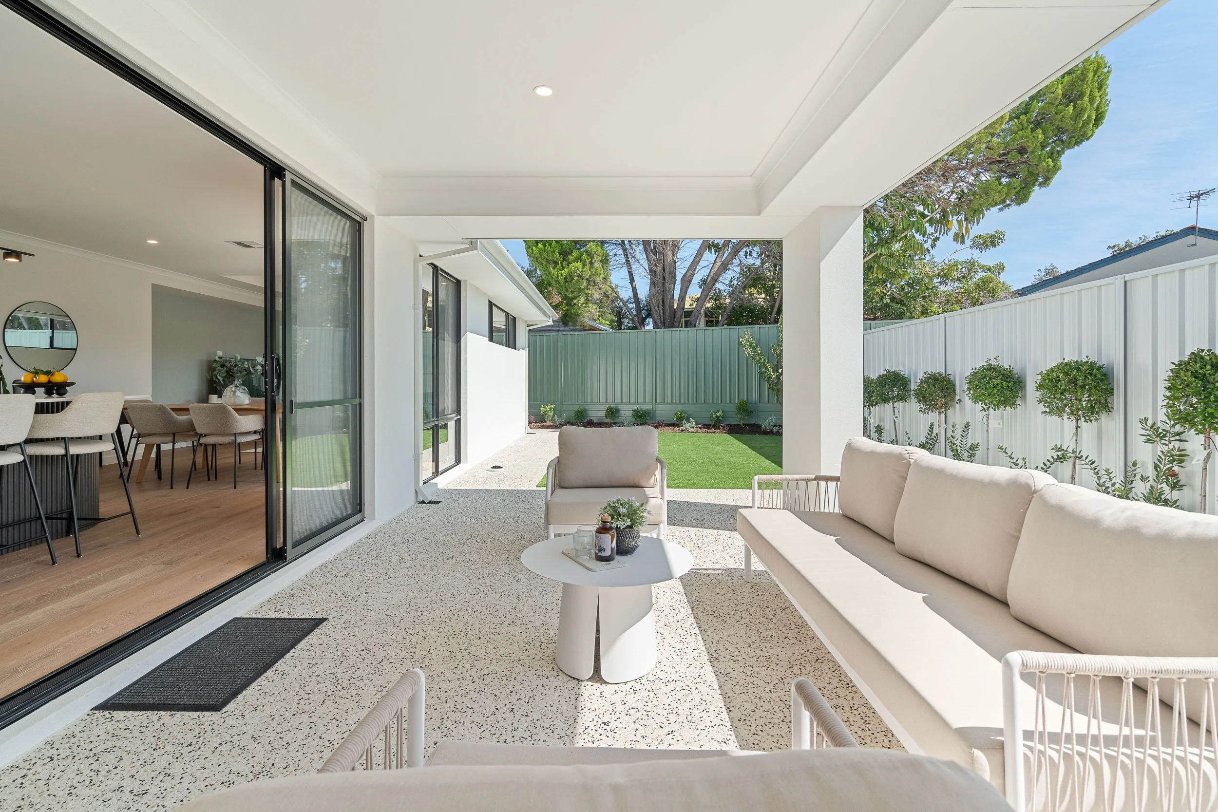 Sheltered courtyard with gravel paving, built-in seating and raised garden beds.