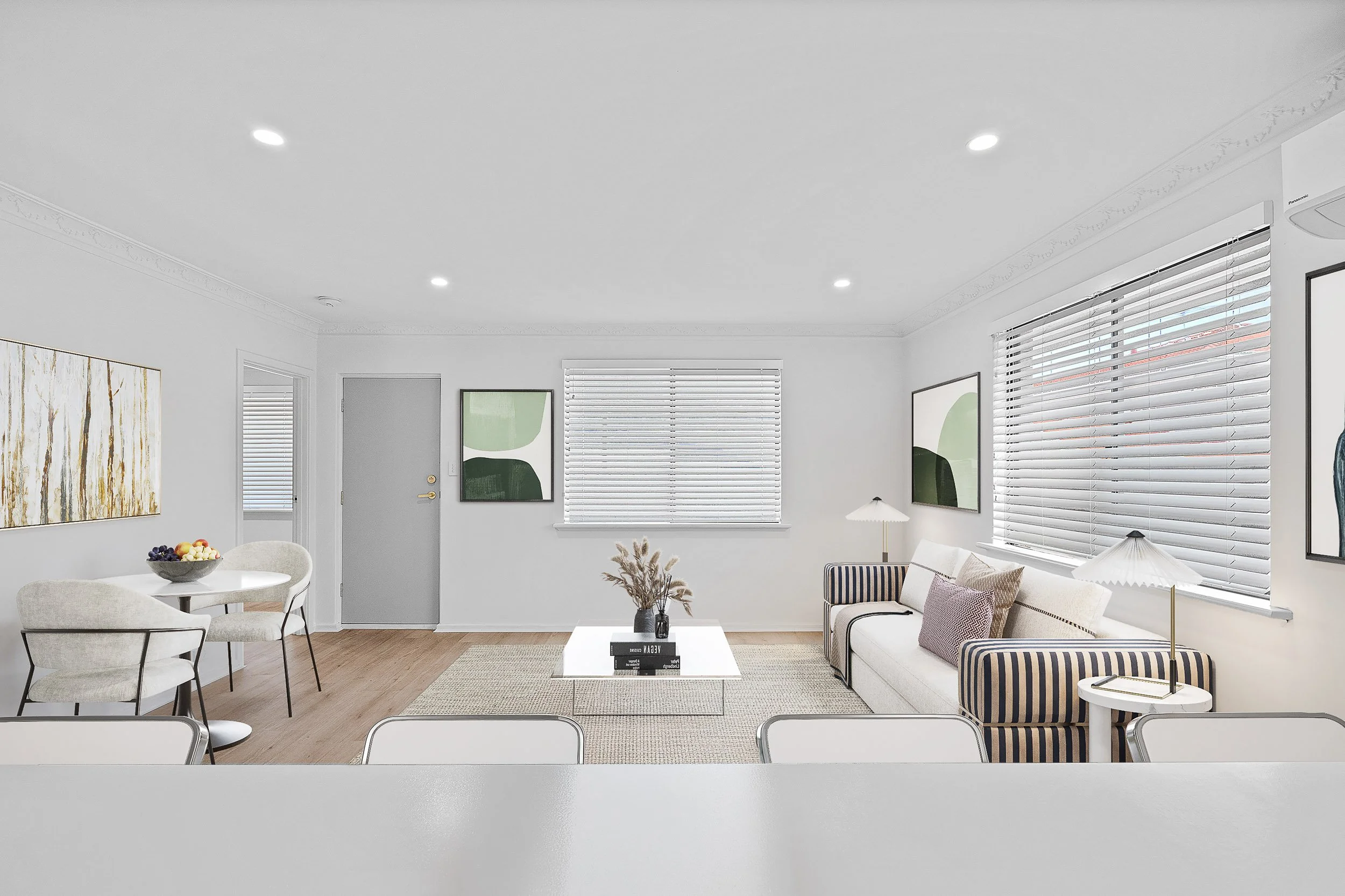 Virtually staged living room with neutral sofas, side tables and a soft textured rug.