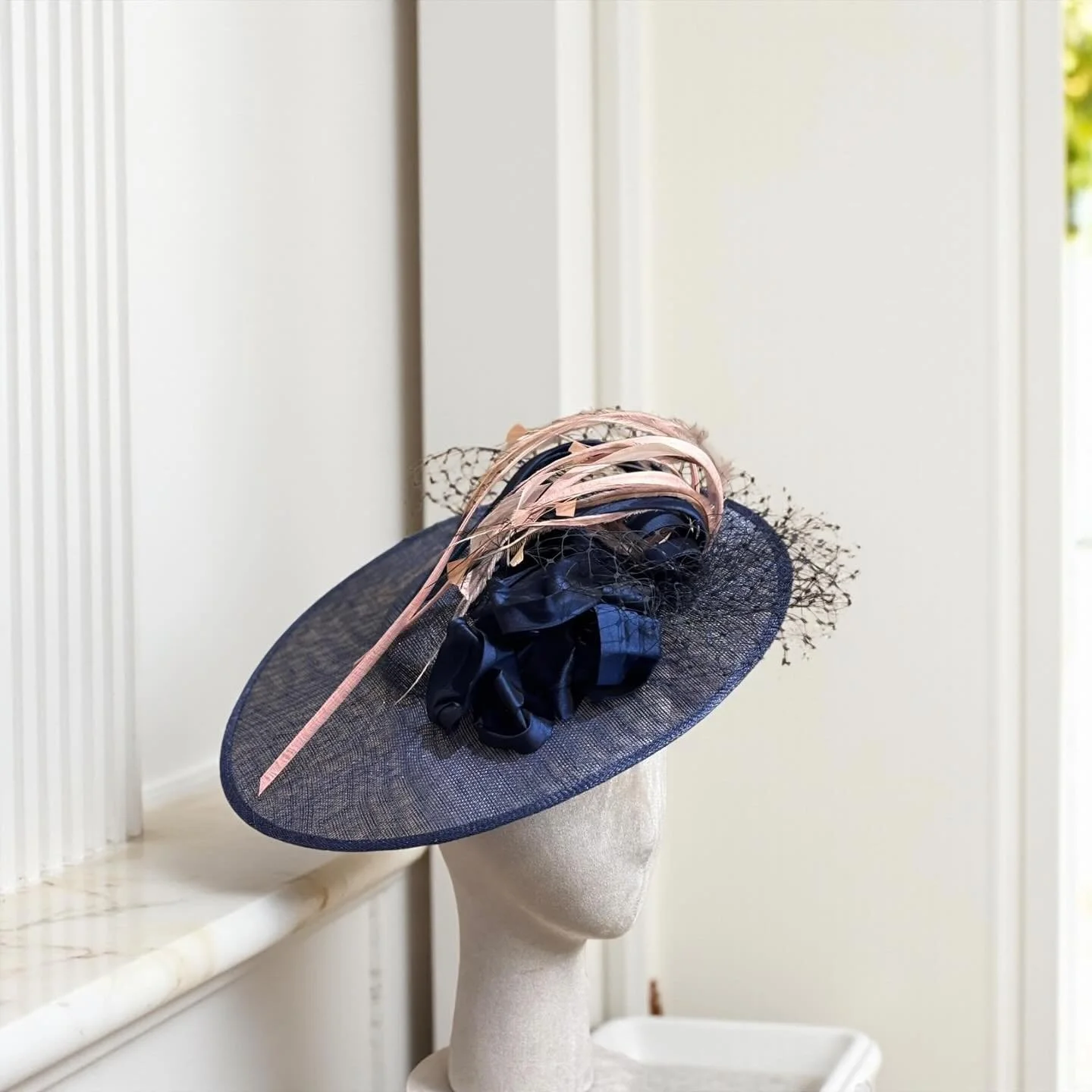 Elenora&hellip;Manifestation of glamour.

This gorgeous hat is made of metallic cartwheel sinamay fascinator base adorned with starched silk dupion navy blue fabric, stripped Coque dots feathers and a glorious birdcage veil shaped in a bow&hellip;

H