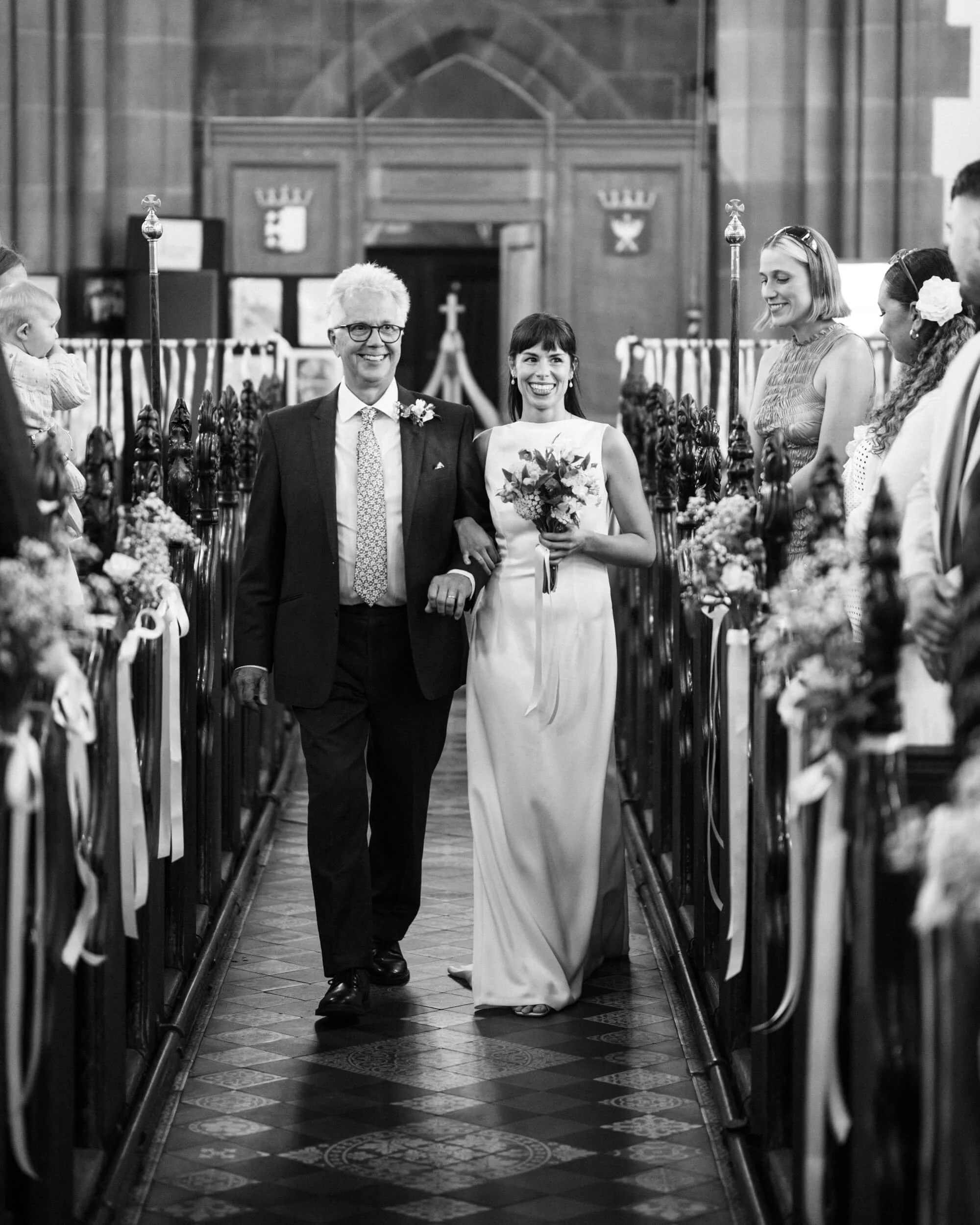 Bride and Father of the Bride walk down the aisle in the church.