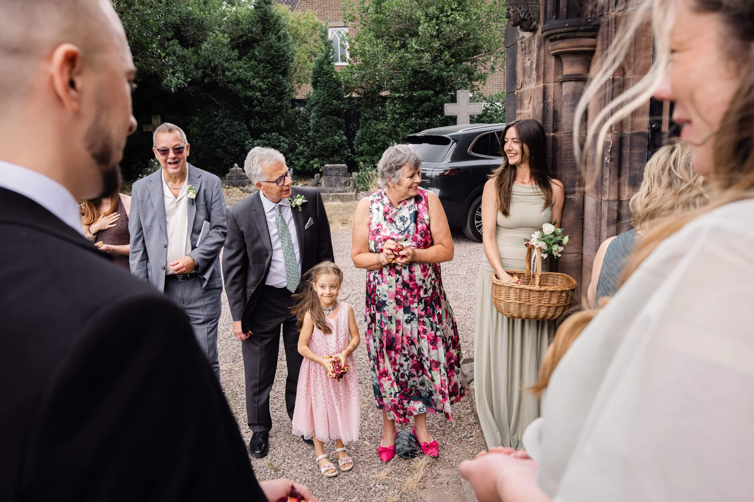 Wedding guests smile at each other as they line up for the confetti line.