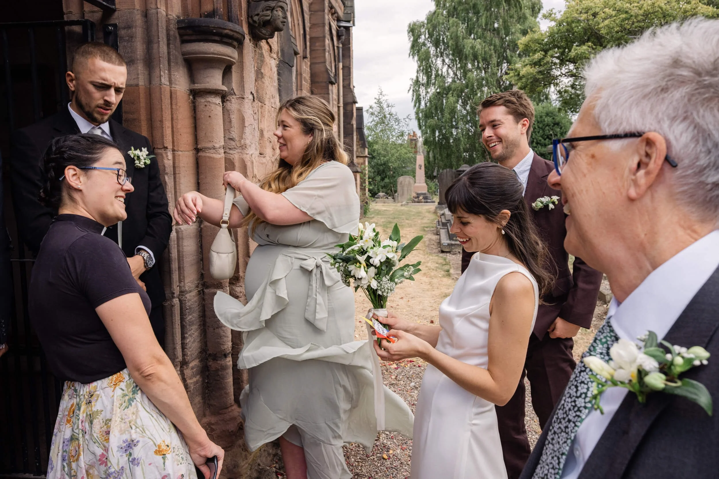 Bride and groom smile as the reverend gives them a gift