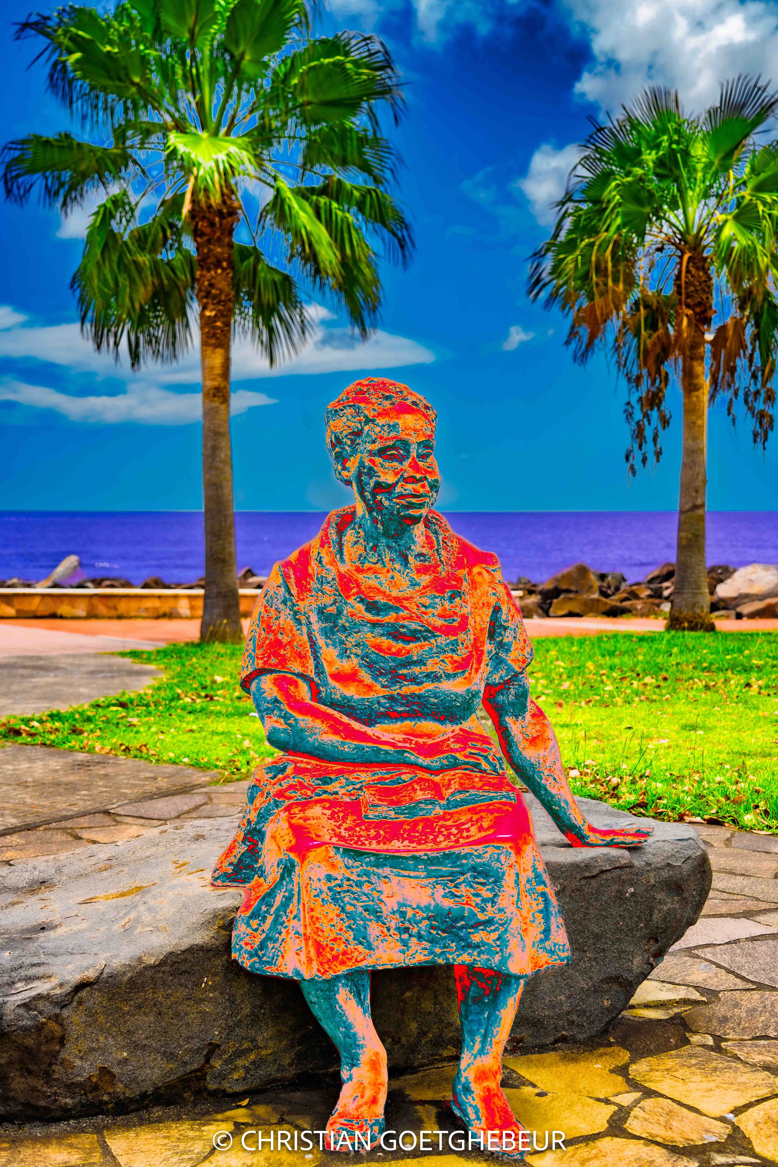 Statue urbaine à Basse-Terre en Guadeloupe, inscrite dans un paysage côtier et architectural.